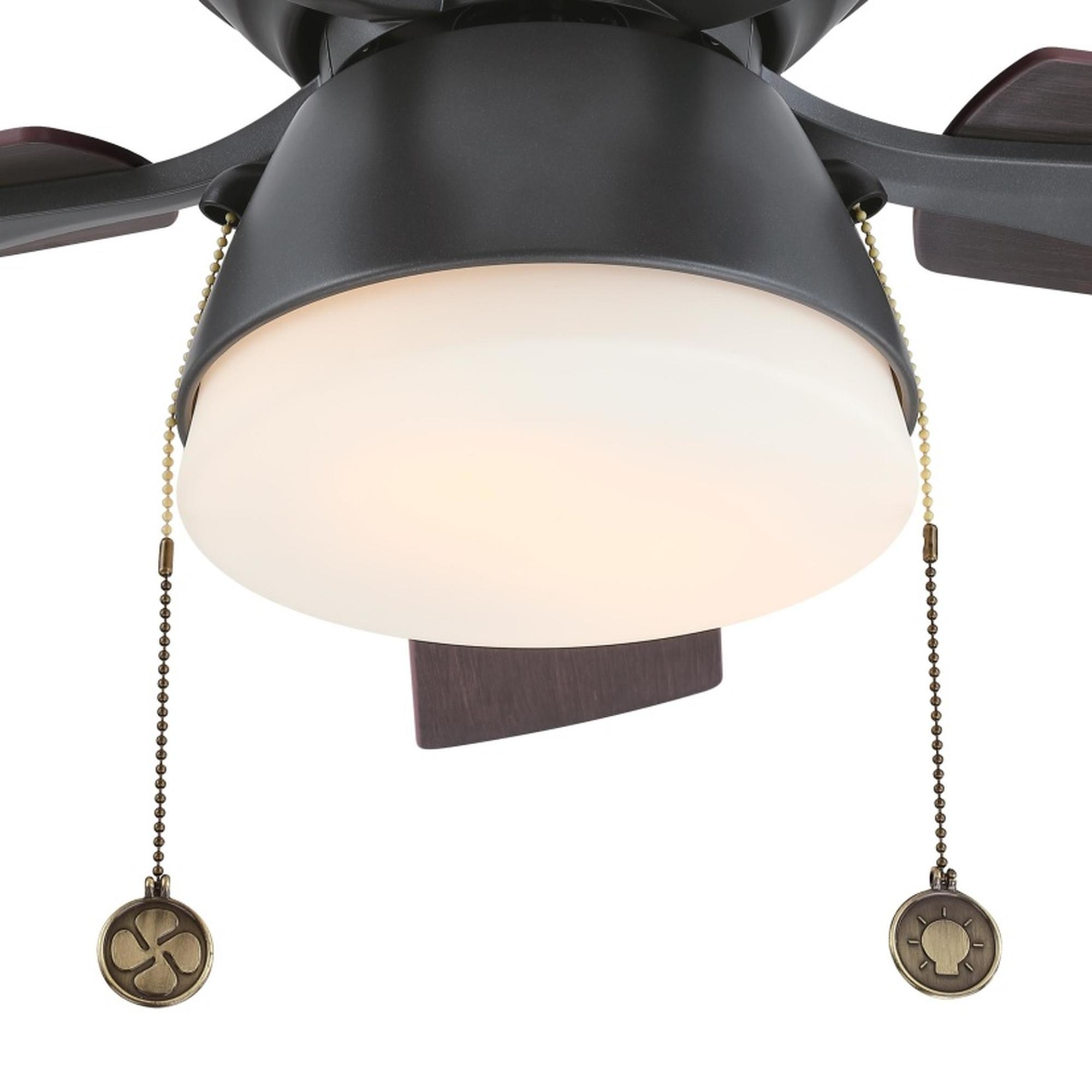 Nahaufnahme eines Deckenventilators mit dunklen Flügeln und Licht. Zugketten sind sichtbar.