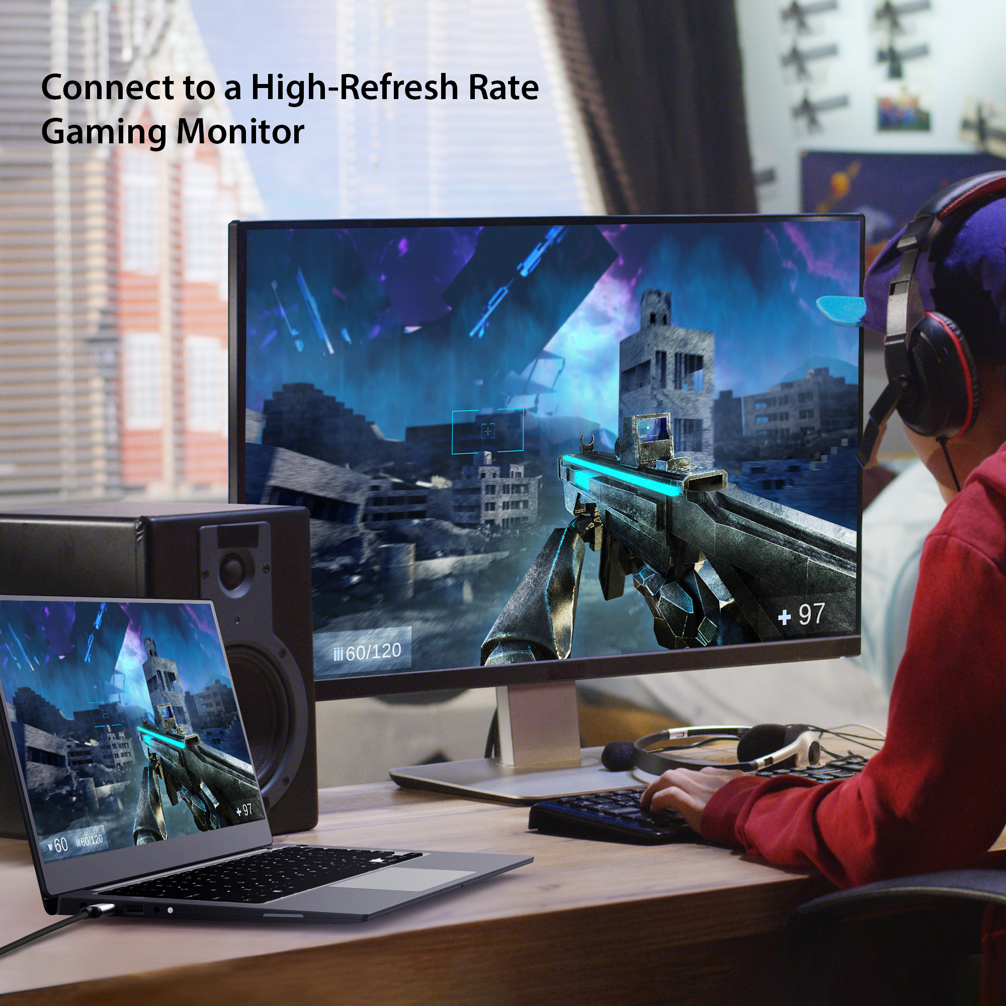 Una persona usando una laptop conectada a un monitor. La pantalla muestra un juego. Hay un altavoz y auriculares.