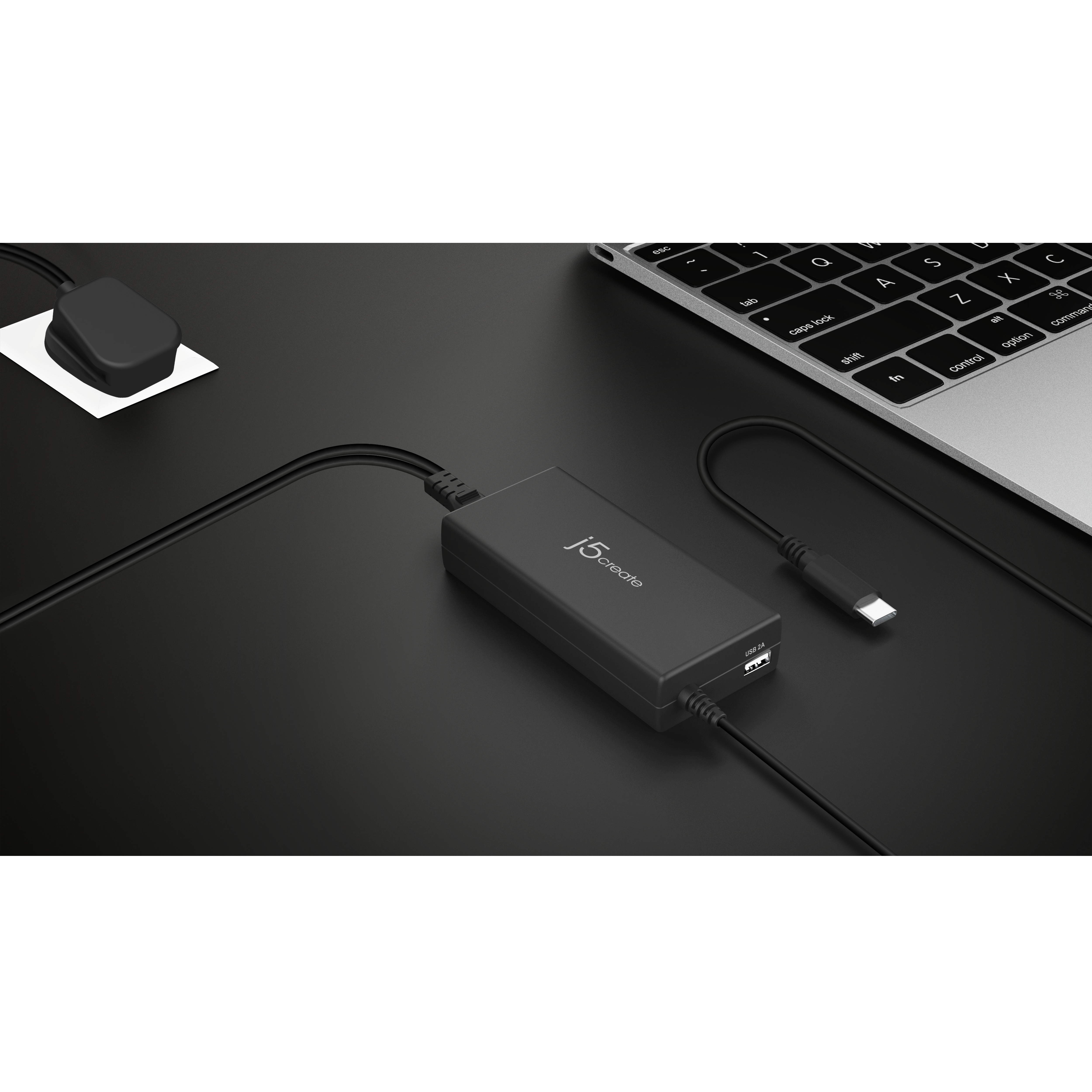 Schwarzes Ladegerät mit USB-Anschluss und USB-C-Kabel. Schwarze Schreibtischoberfläche.
