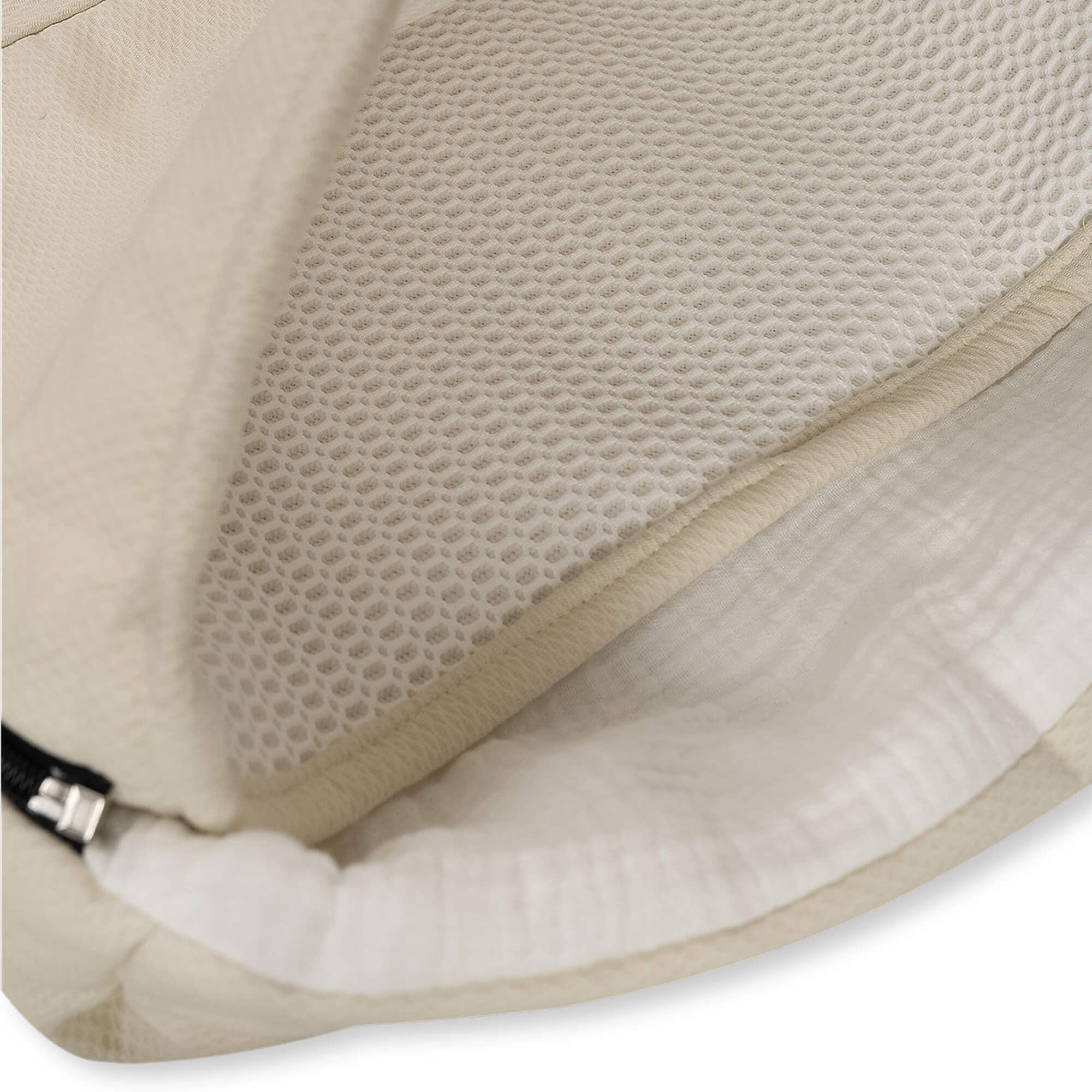 Primer plano de hamaca para bebé color crema. Malla blanca y cojín beige. Fondo blanco.