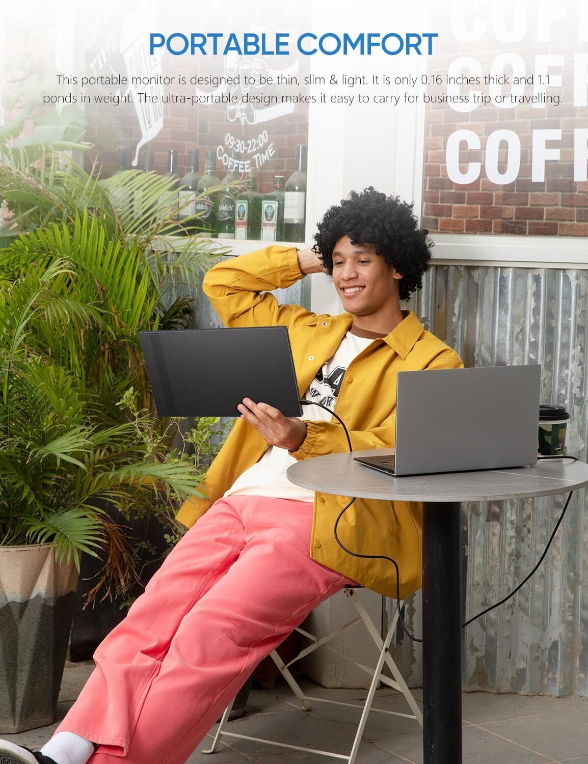 Hombre usando monitor portátil con laptop. Contexto de café.