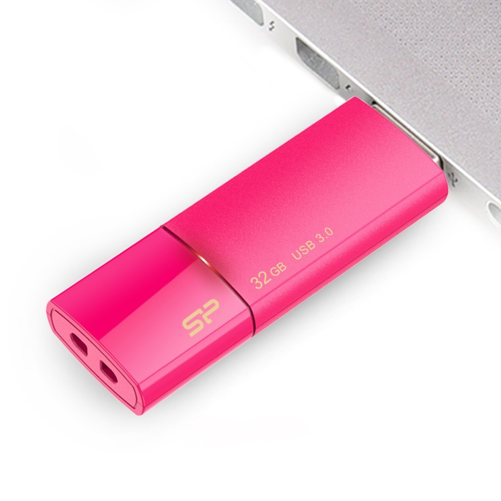 Chiavetta USB rosa da 32 GB con logo SP, collegata a un laptop.