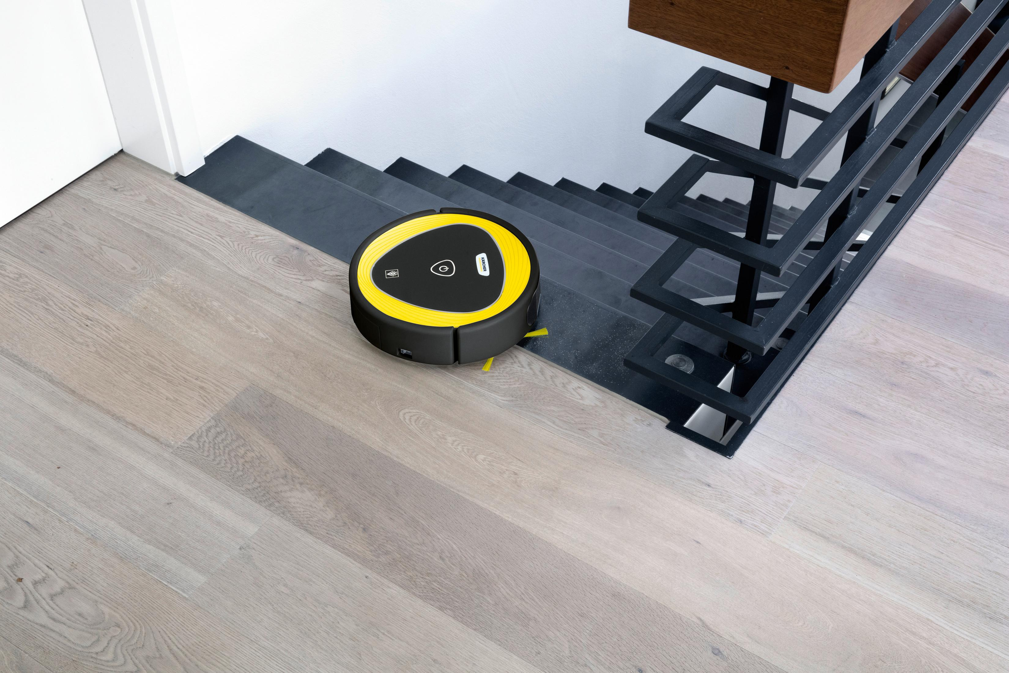 Robot aspirapolvere che pulisce vicino alle scale con un design moderno.