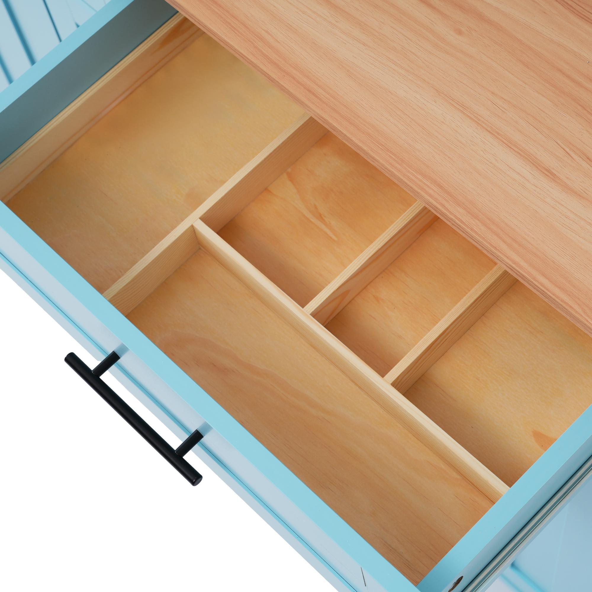 Holzschubladen-Innenraum mit Unterteilungen in einem blauen Schrank, Holzplatte sichtbar.