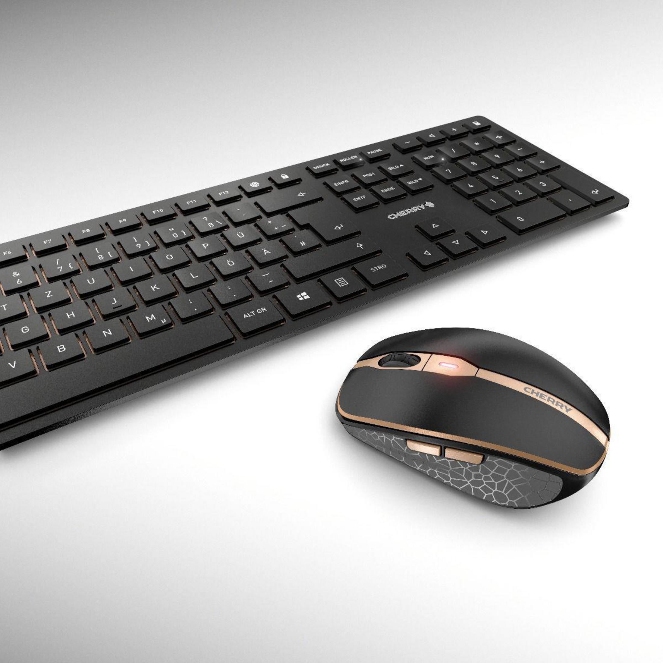 Tastiera e mouse neri con dettagli dorati su sfondo bianco. Marchio CHERRY.