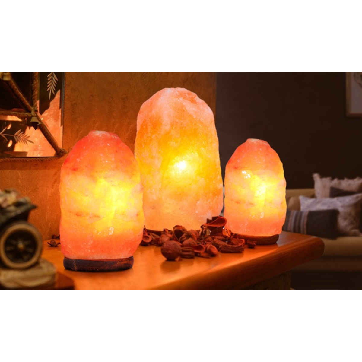 Tres lámparas de sal brillantes sobre una mesa con elementos decorativos.