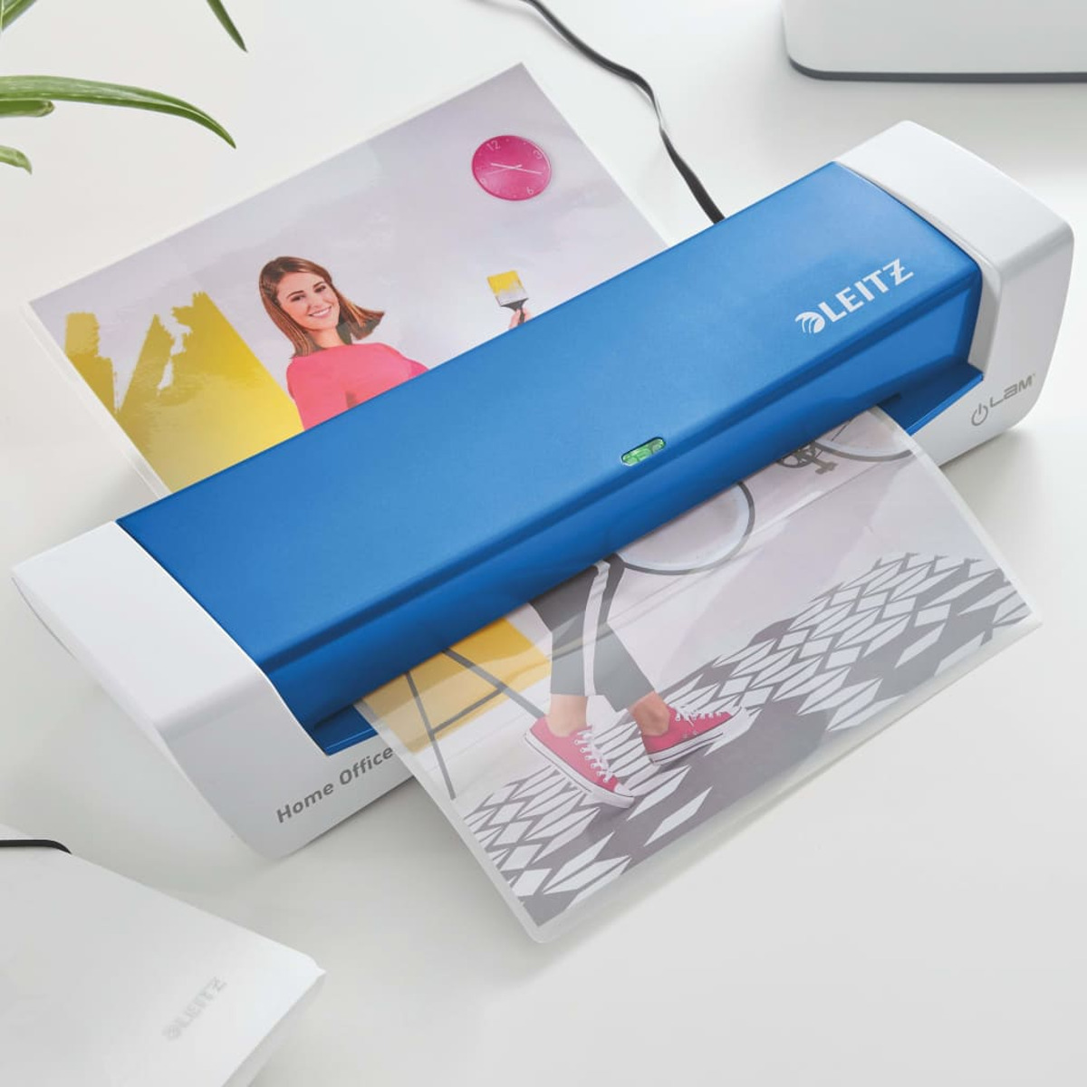 Blau-weißer Leitz Home Office Laminator, der ein Bild mit einer Frau und einer Uhr laminiert.