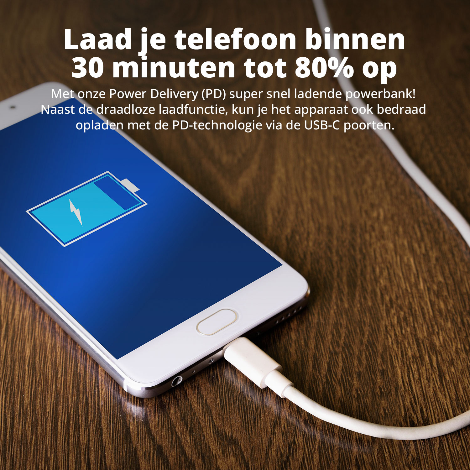 Un téléphone se chargeant avec un câble blanc sur une table en bois.