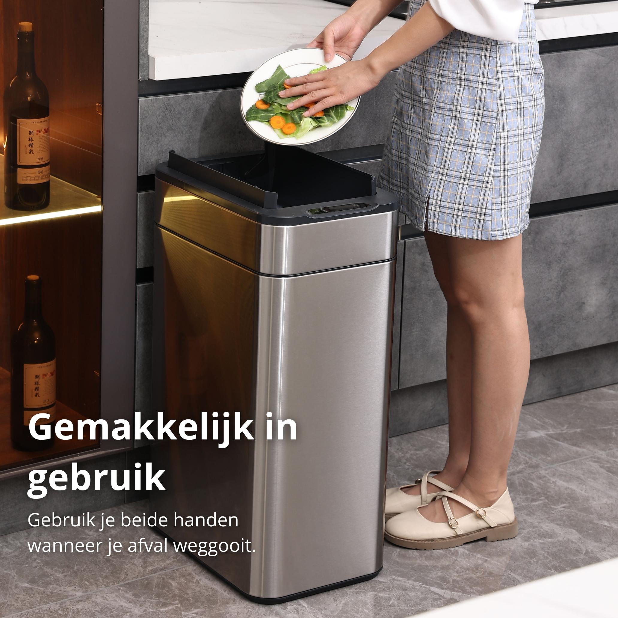 A woman putting food waste into a stainless steel trash can. Kitchen setting.