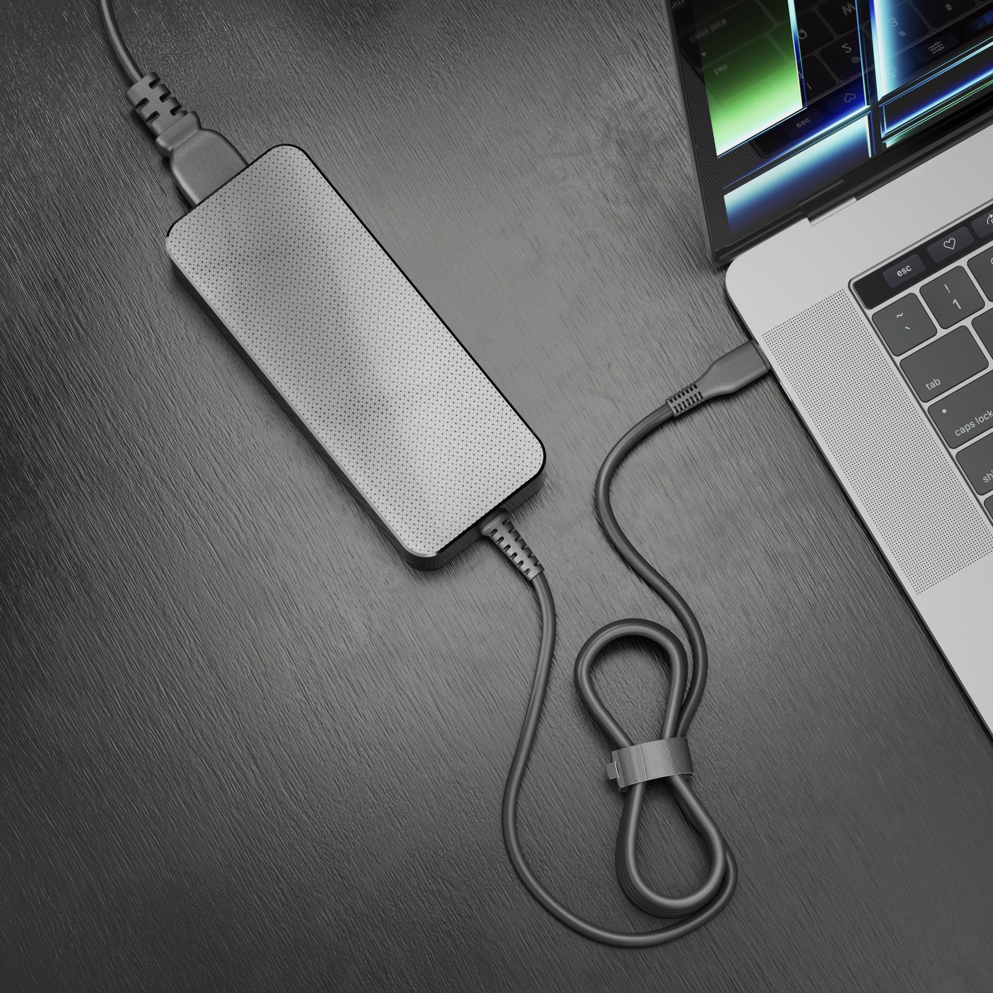 Laptop con caricabatterie collegato. Il caricabatterie è grigio e collegato al laptop.
