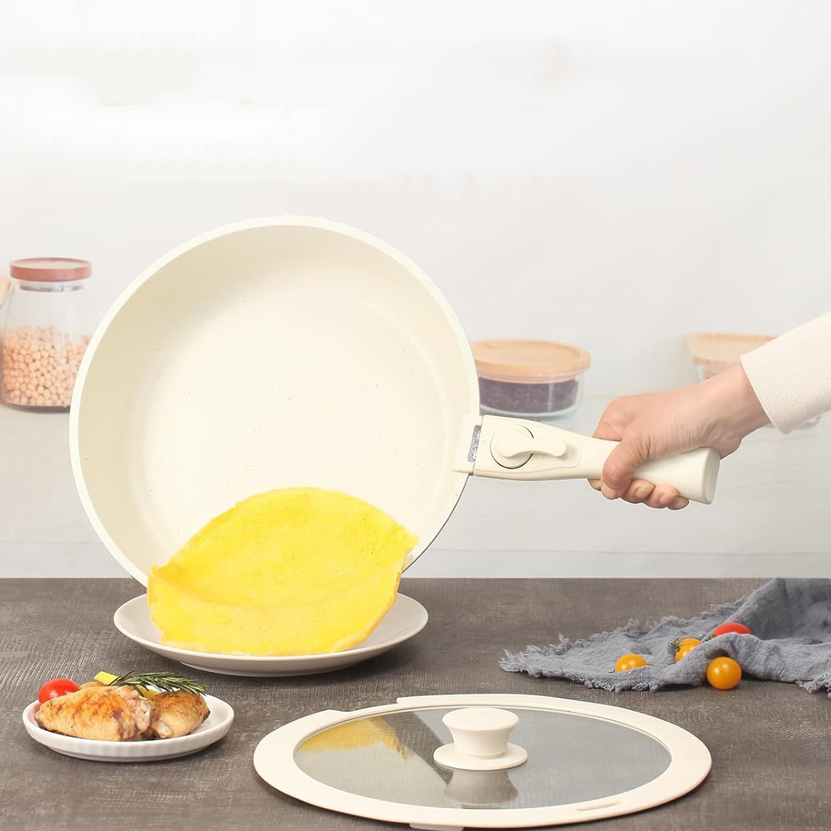 Una persona vierte una tortilla de una sartén blanca. Un plato y una tapa están sobre la mesa.