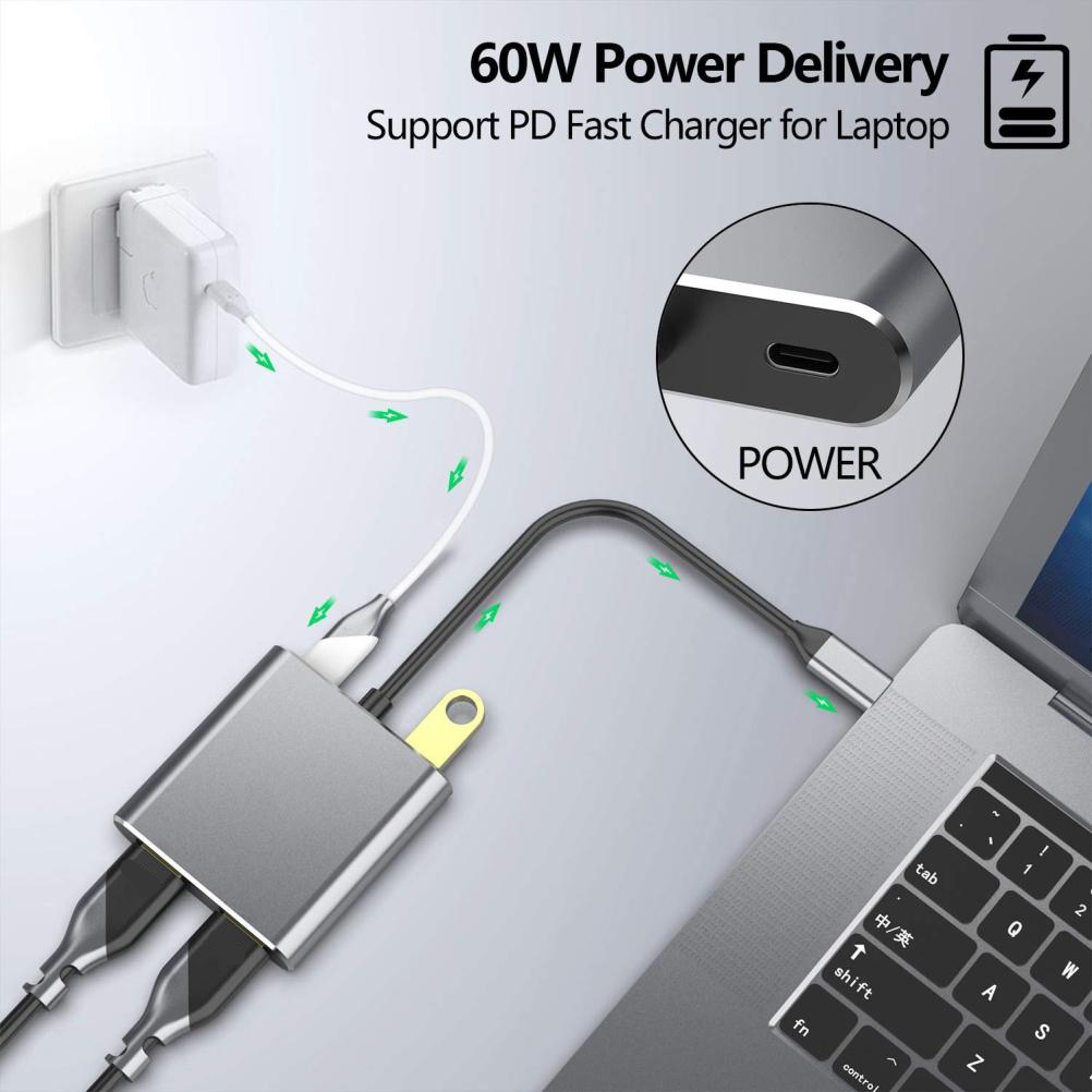 Laptop mit einem Lade-Hub über einen Netzadapter verbunden. Grauer Hub mit mehreren Anschlüssen, schwarzes Kabel.