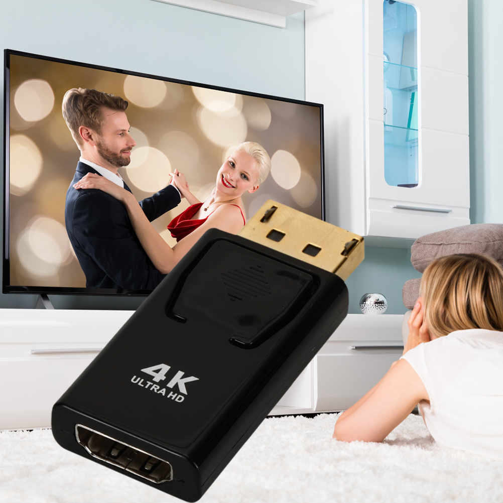 Schwarzer Adapter, der an einen Fernseher angeschlossen ist, der ein tanzendes Paar zeigt.