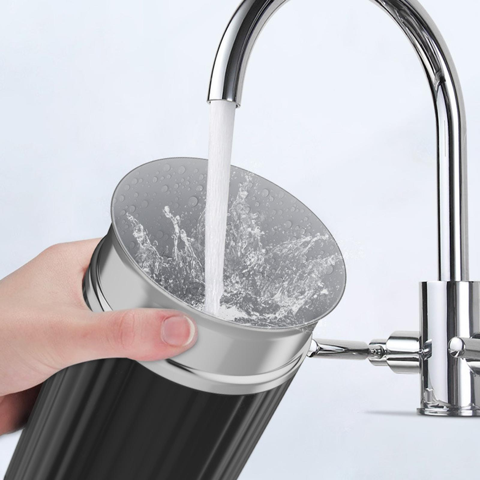 Eine Hand, die Wasser in einen schwarzen Behälter mit silbernem Rand gießt.