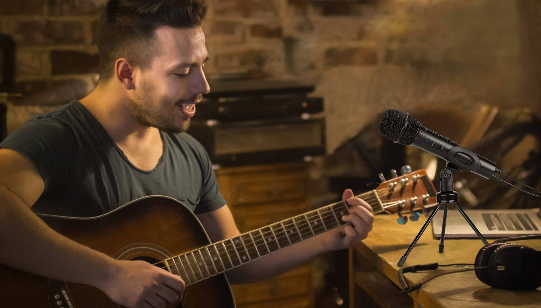 Mann spielt Gitarre, Mikrofon auf einem Ständer und Kopfhörer.