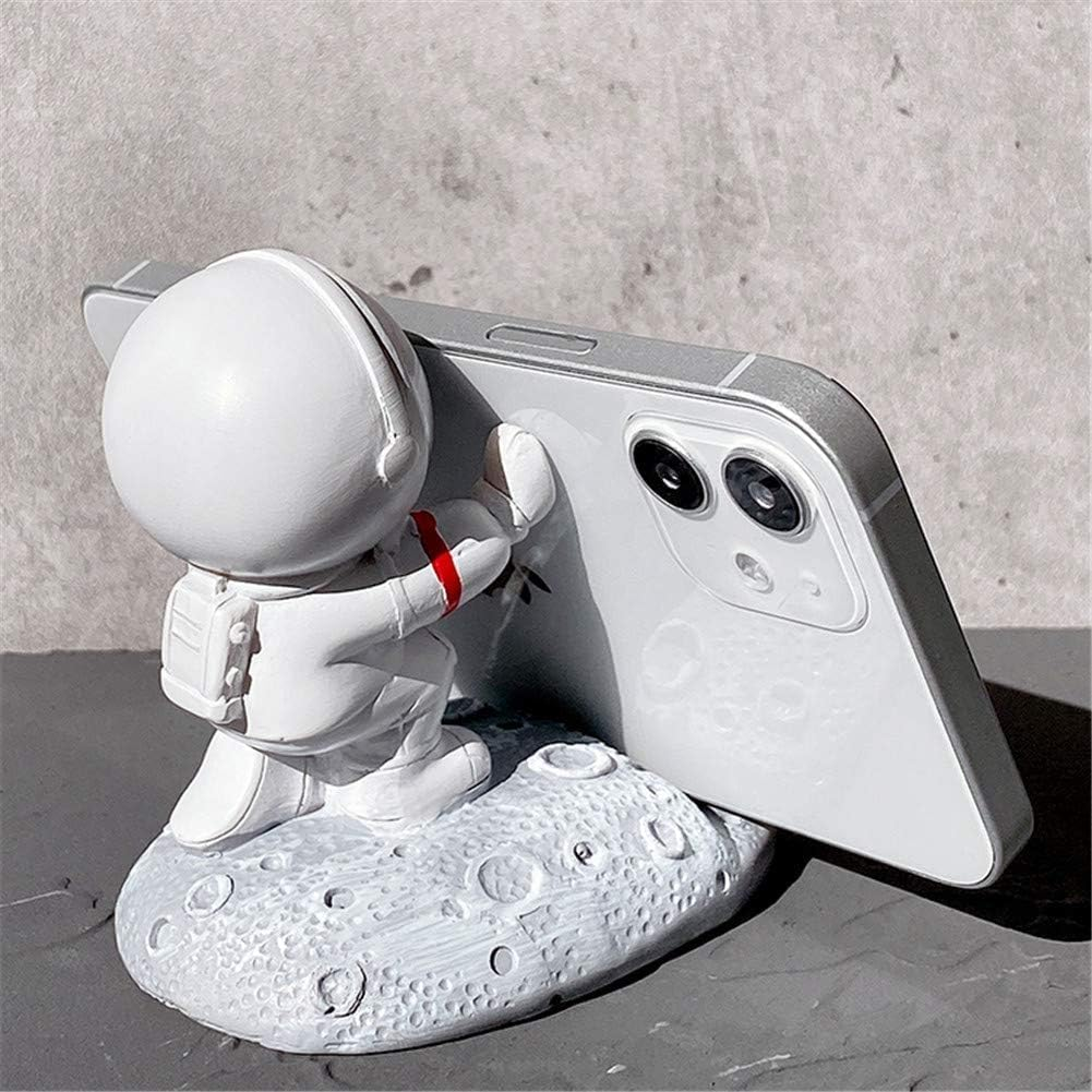 Weiße Astronautenfigur, die ein Telefon hält. Das Telefon ist silberfarben, Astronaut auf Mondbasis.
