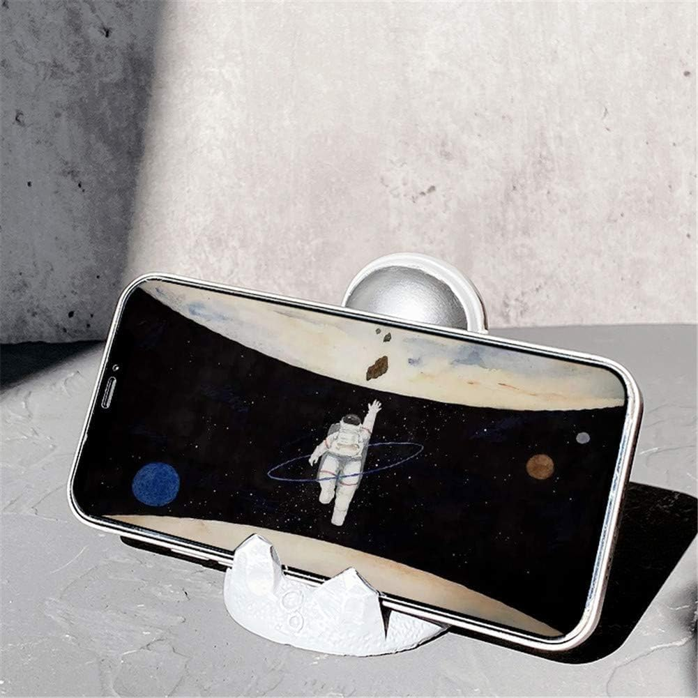Smartphone auf einem Ständer, der einen Astronauten im Weltraum zeigt. Ein weißer Ständer und eine graue Wand im Hintergrund.