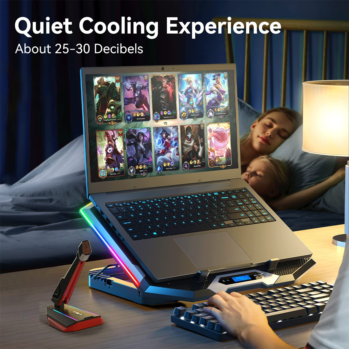 Laptop auf Kühlständer mit Spielszene auf dem Bildschirm. Im Hintergrund liegen zwei Personen im Bett.