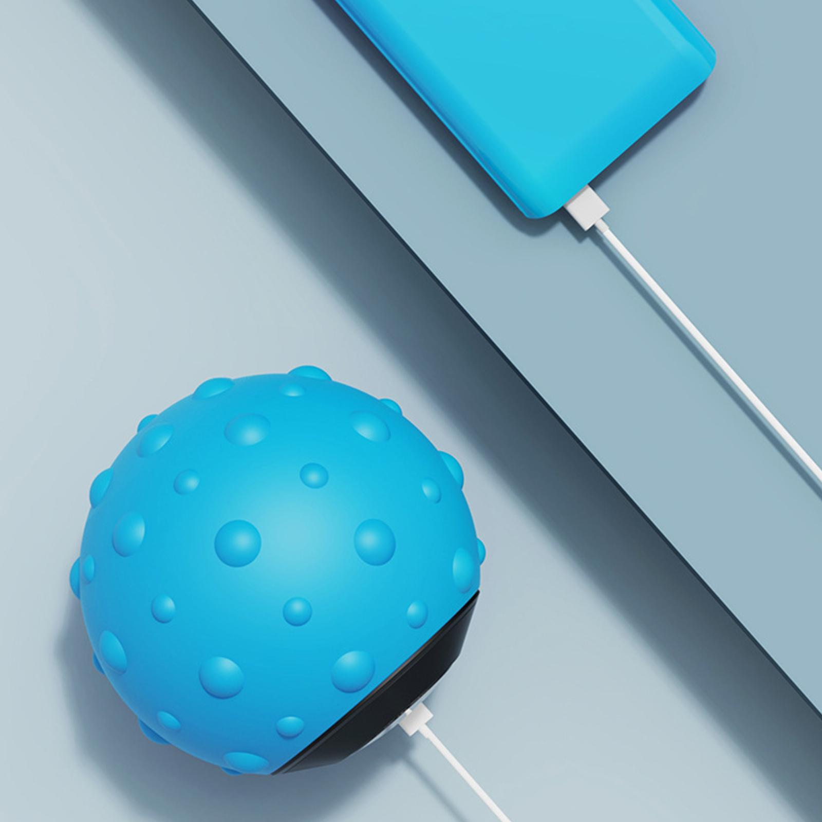 Blauer Massageball, der mit einem weißen Kabel an einem blauen Telefon geladen wird.