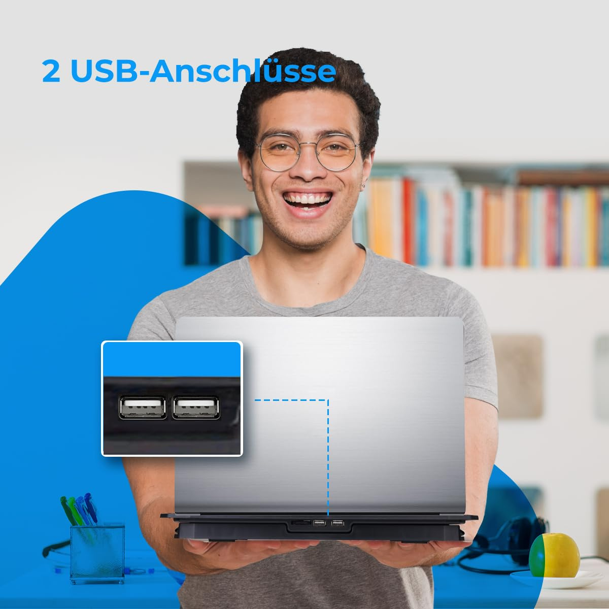 Mann lächelt, trägt eine Brille, mit Laptop auf einem Ständer. Zwei USB-Anschlüsse sind sichtbar.