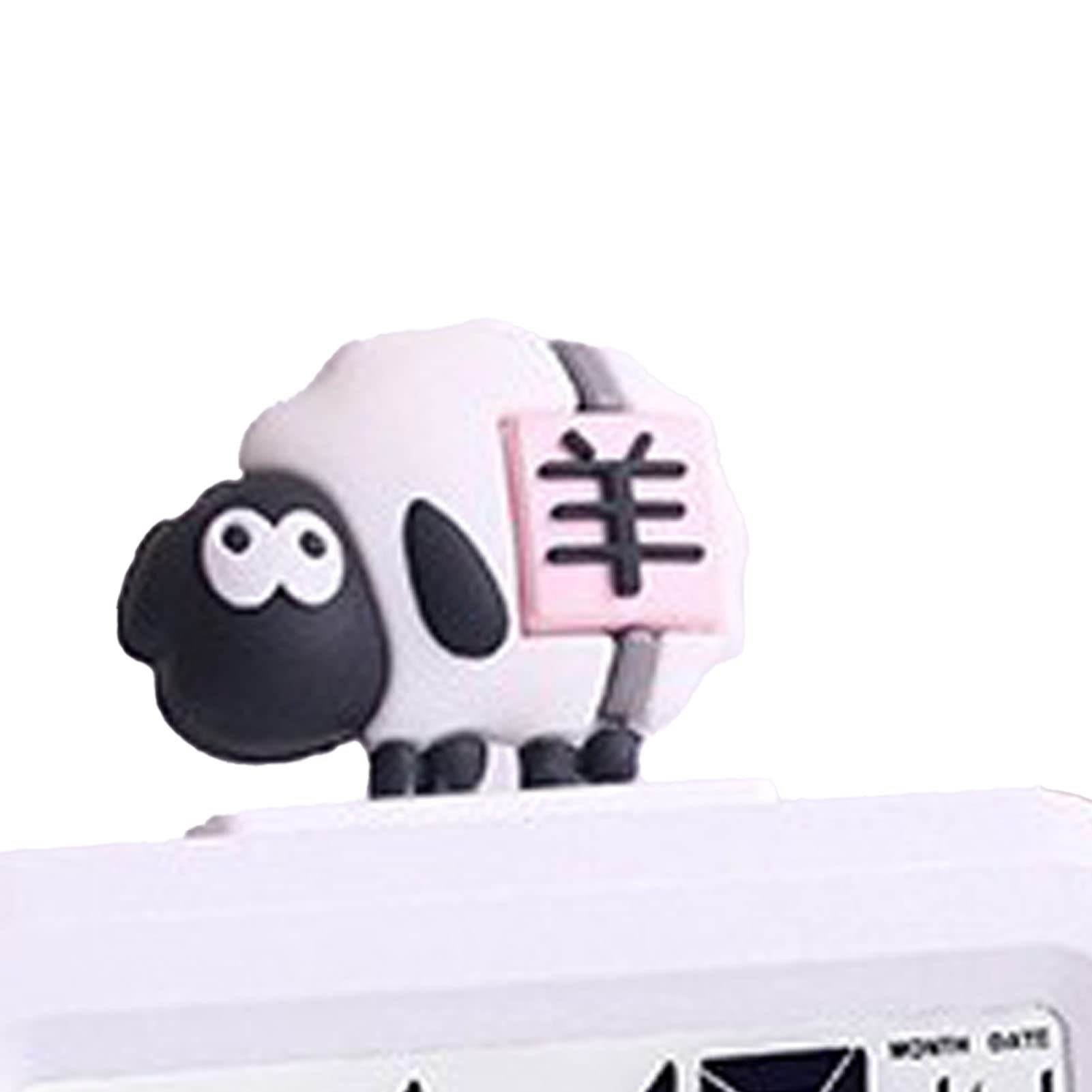Eine Schaf-Figur mit chinesischen Schriftzeichen auf einem pinkfarbenen Schild sitzt auf einer weißen Uhr.