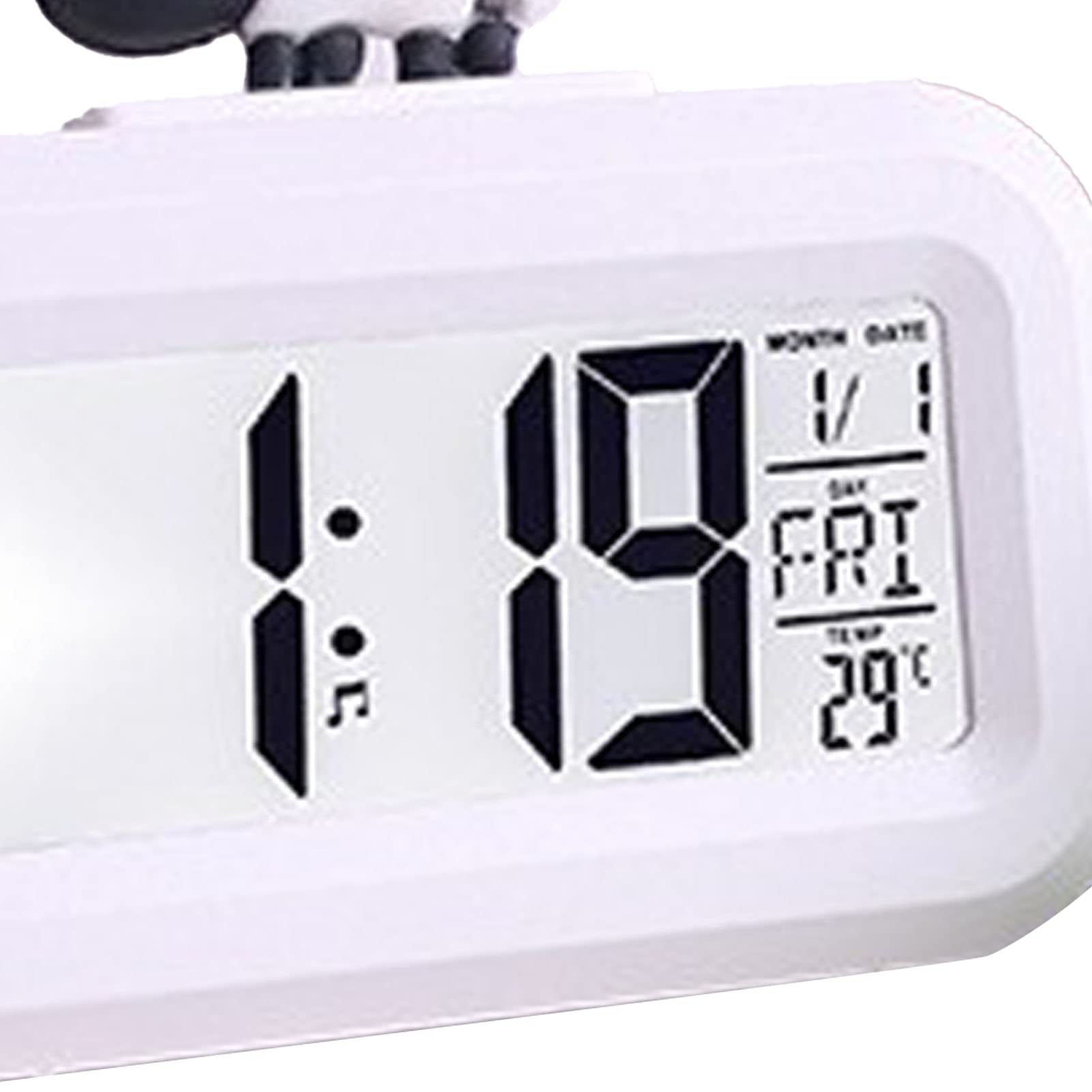 Weißer Digitalwecker mit 1:19 Uhr und einer Kuh oben drauf. Zeit, Datum und Temperatur sichtbar.