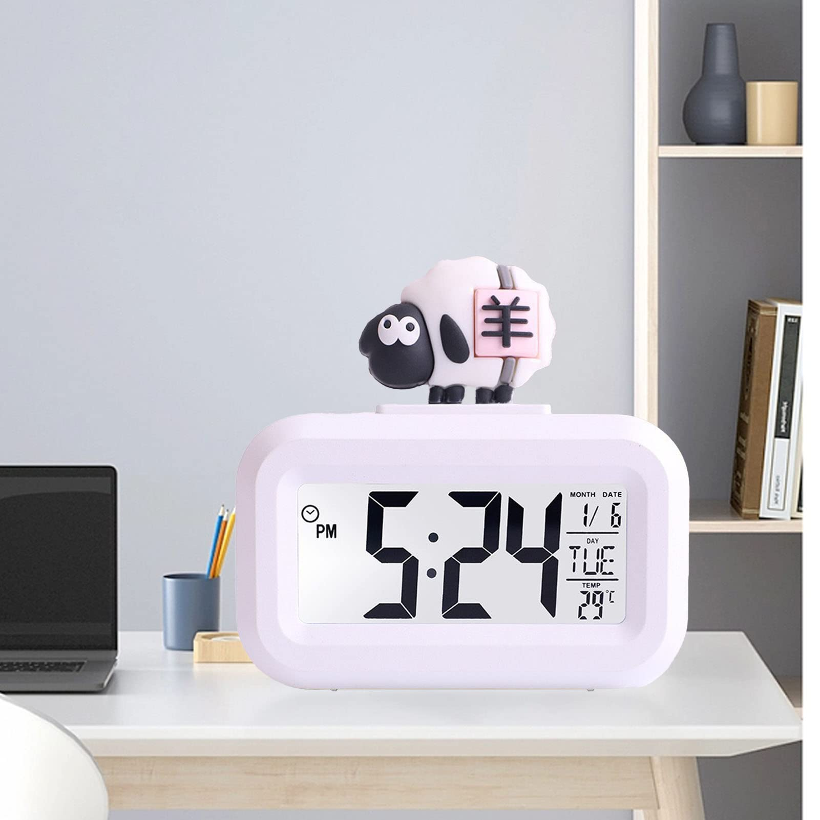 Eine rosa schafartige Uhr auf einem Schreibtisch zeigt 5:24, Datum 1/6, Temp. 29°C.