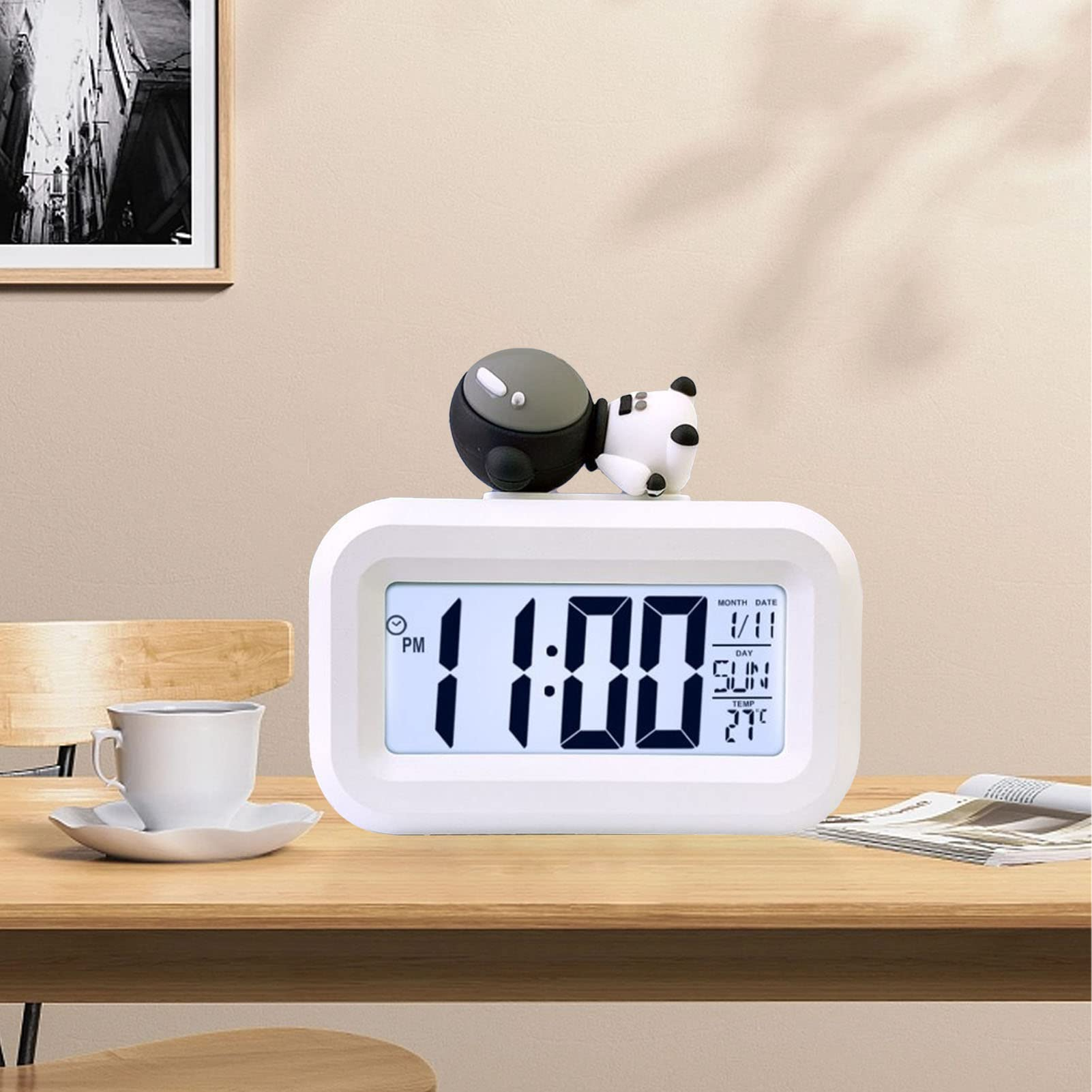 Weißer Digitalwecker mit Panda. Zeigt 23:00, Datum, Tag und Temperatur auf Holzoberfläche.