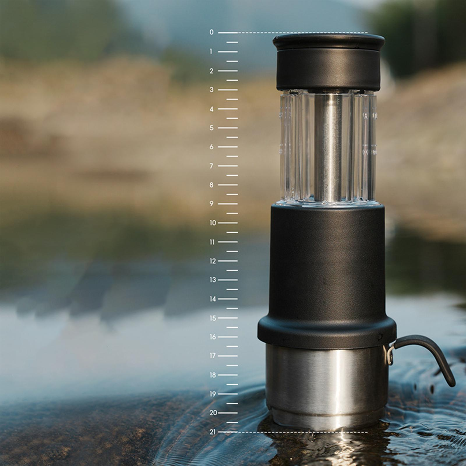 Ein schwarz-silbernes Wasserfiltergerät in einem Bach mit einem Lineal, das Messungen zeigt.