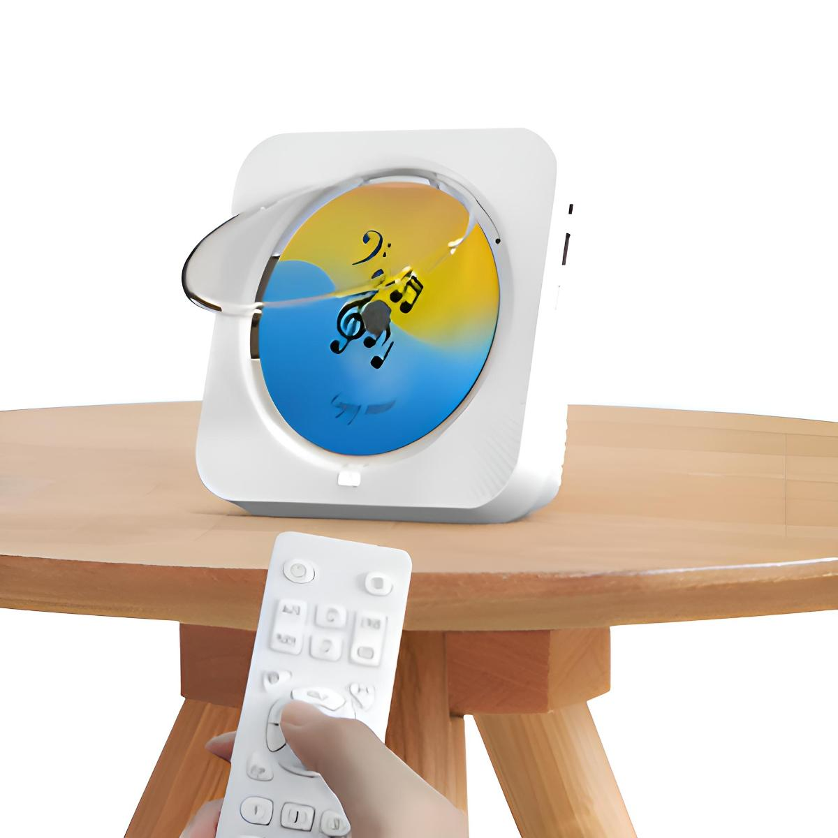 Ein weißer tragbarer CD-Player mit eingelegter CD auf einem Holztisch. Eine Fernbedienung in einer Hand im Vordergrund.