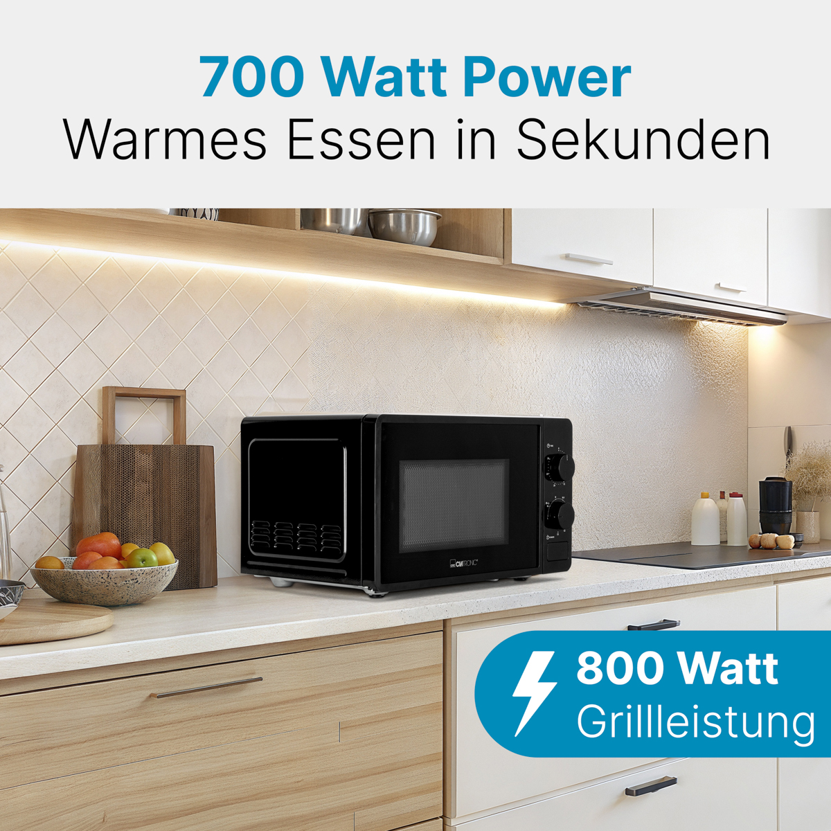 Czarna kuchenka mikrofalowa na blacie kuchennym. Tekst wskazuje moc i moc grilla. Kuchnia w tle.