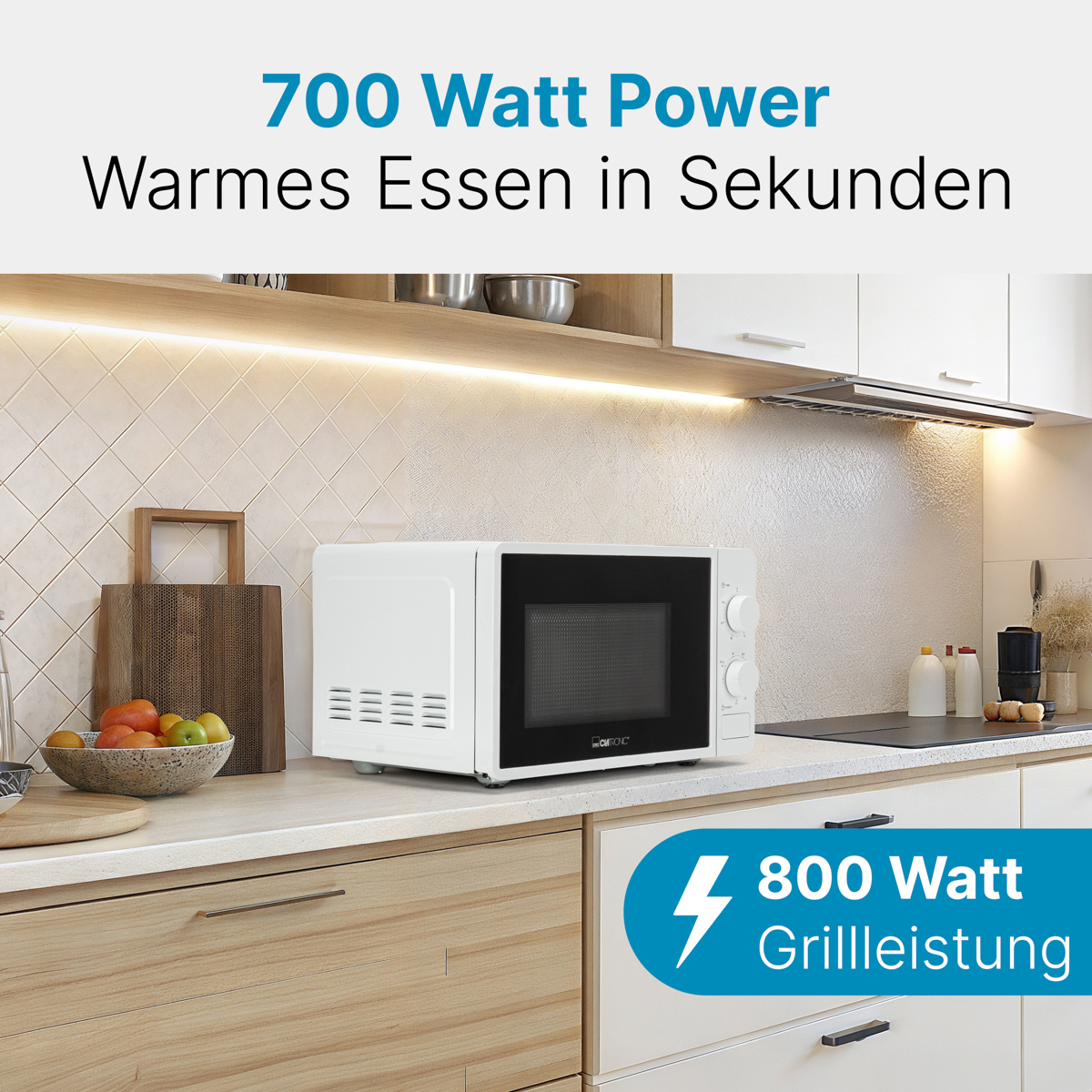 Biała kuchenka mikrofalowa na blacie kuchennym. Teksty: 700 Watt Power, Warmes Essen in Sekunden i 800 Watt Grillleistung.