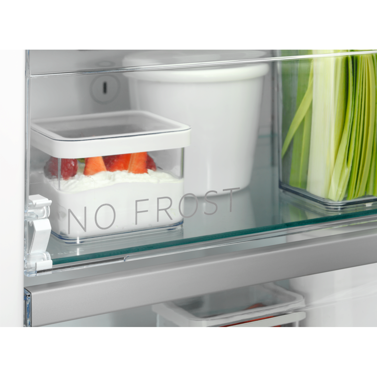 Primer plano de un estante de refrigerador con 'NO FROST' y recipientes de fresas.