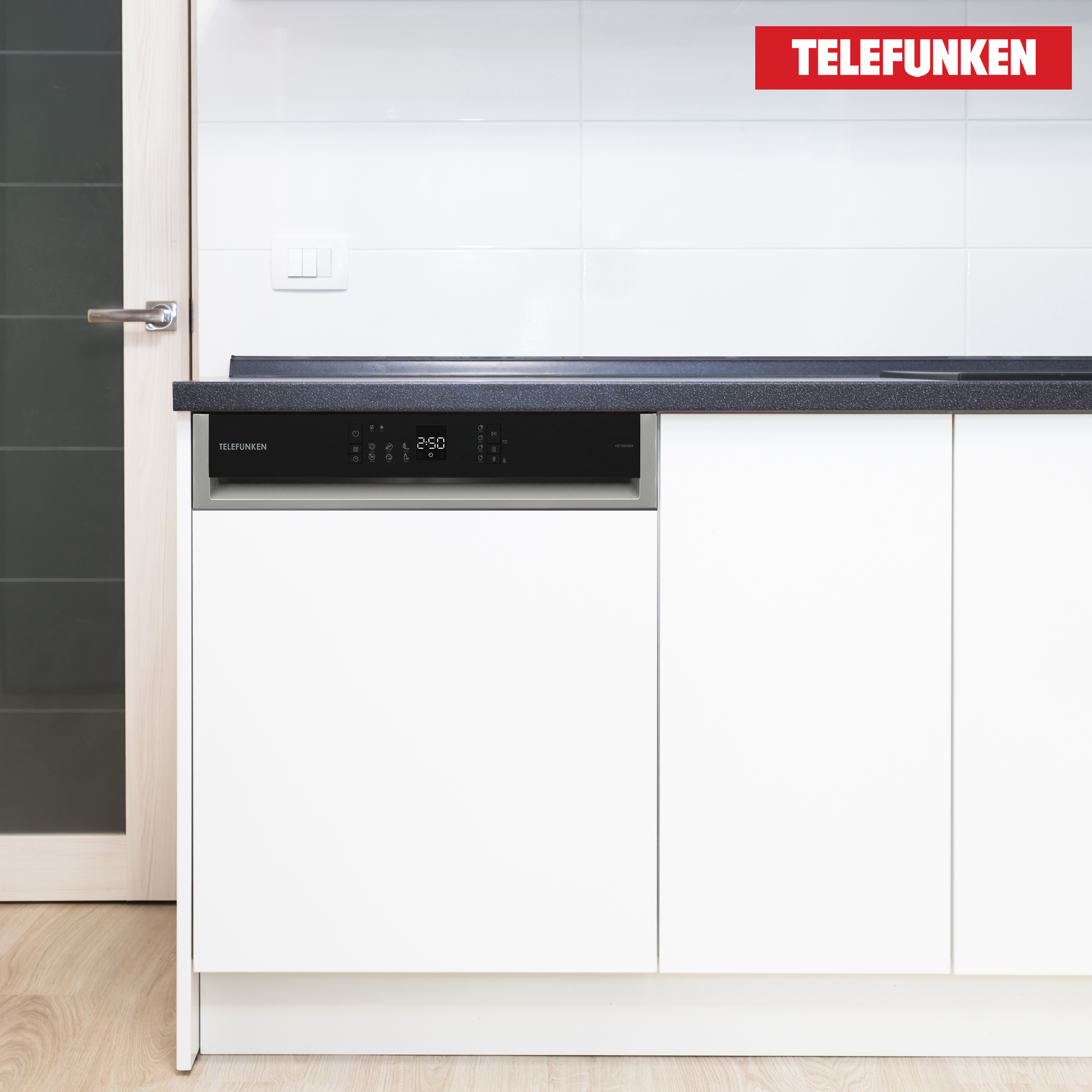 Eine Telefunken-Spülmaschine in einer Küche. Die Schränke sind weiß, die Arbeitsplatte ist dunkel.