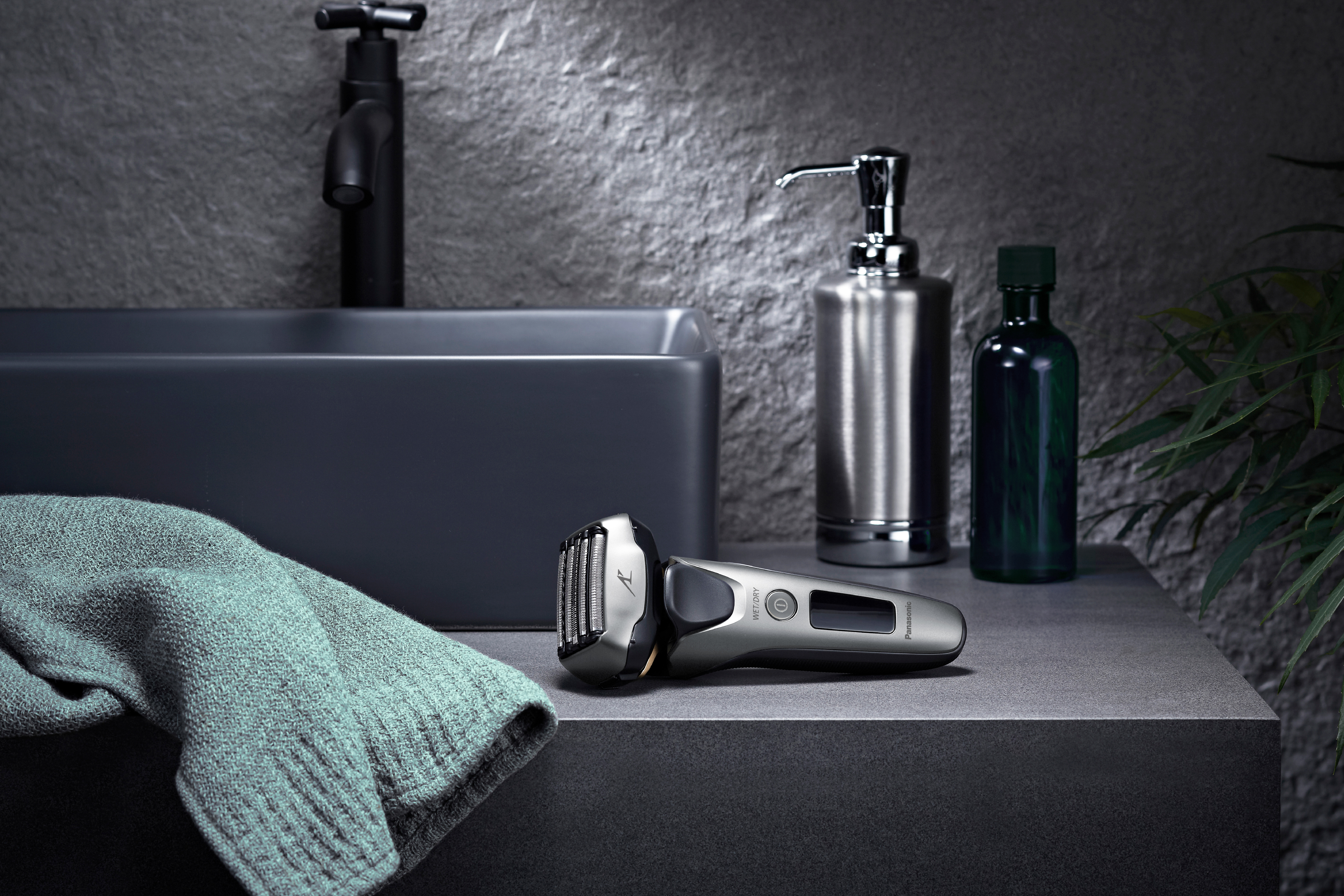 Une scène de salle de bain avec un rasoir sur un comptoir, du savon et une bouteille verte.