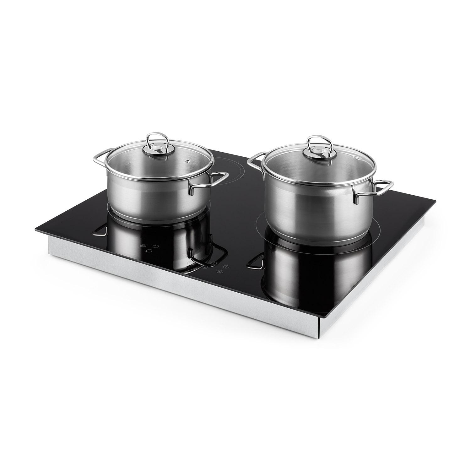 Due pentole in acciaio inox con coperchi in vetro su un piano cottura a induzione nero.