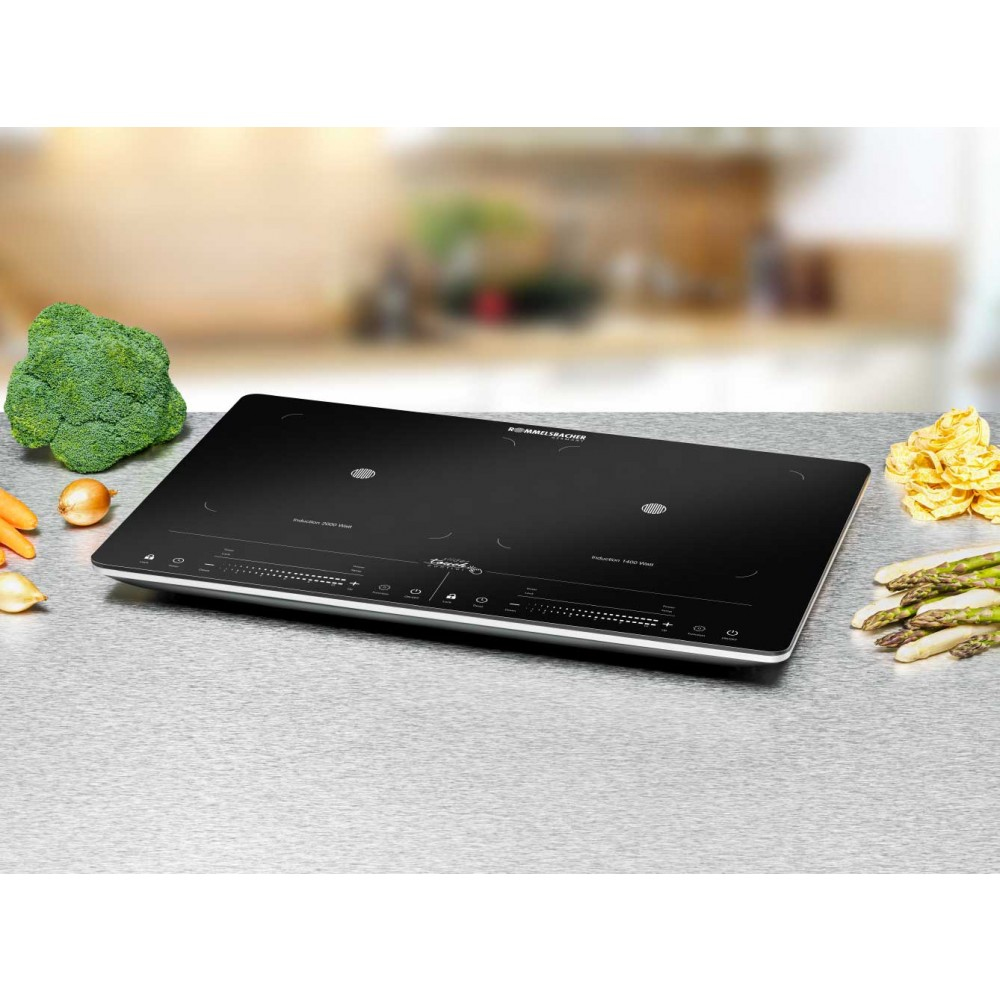 Czarna płyta indukcyjna z dwoma strefami gotowania, brokułami i warzywami.
