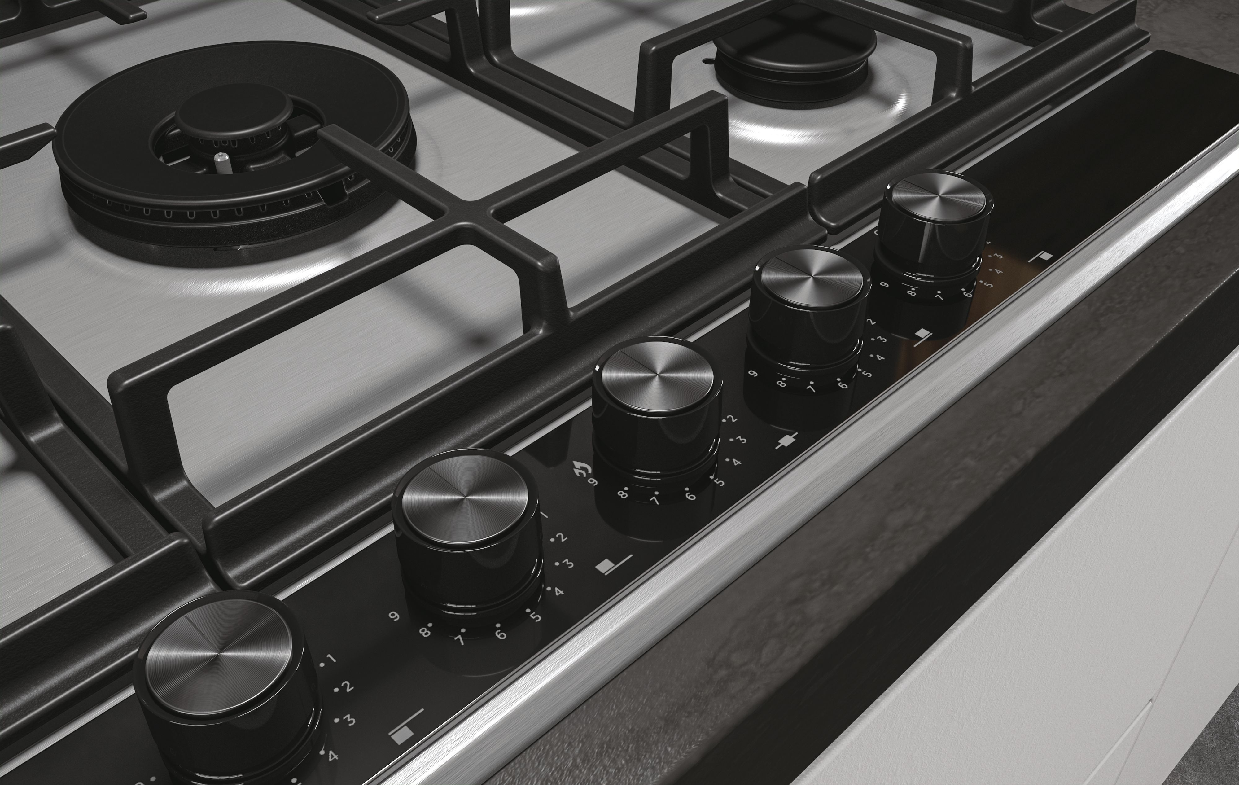Zbliżenie pokręteł sterowania płyty gazowej. Czarne pokrętła z oznaczeniami numerycznymi.