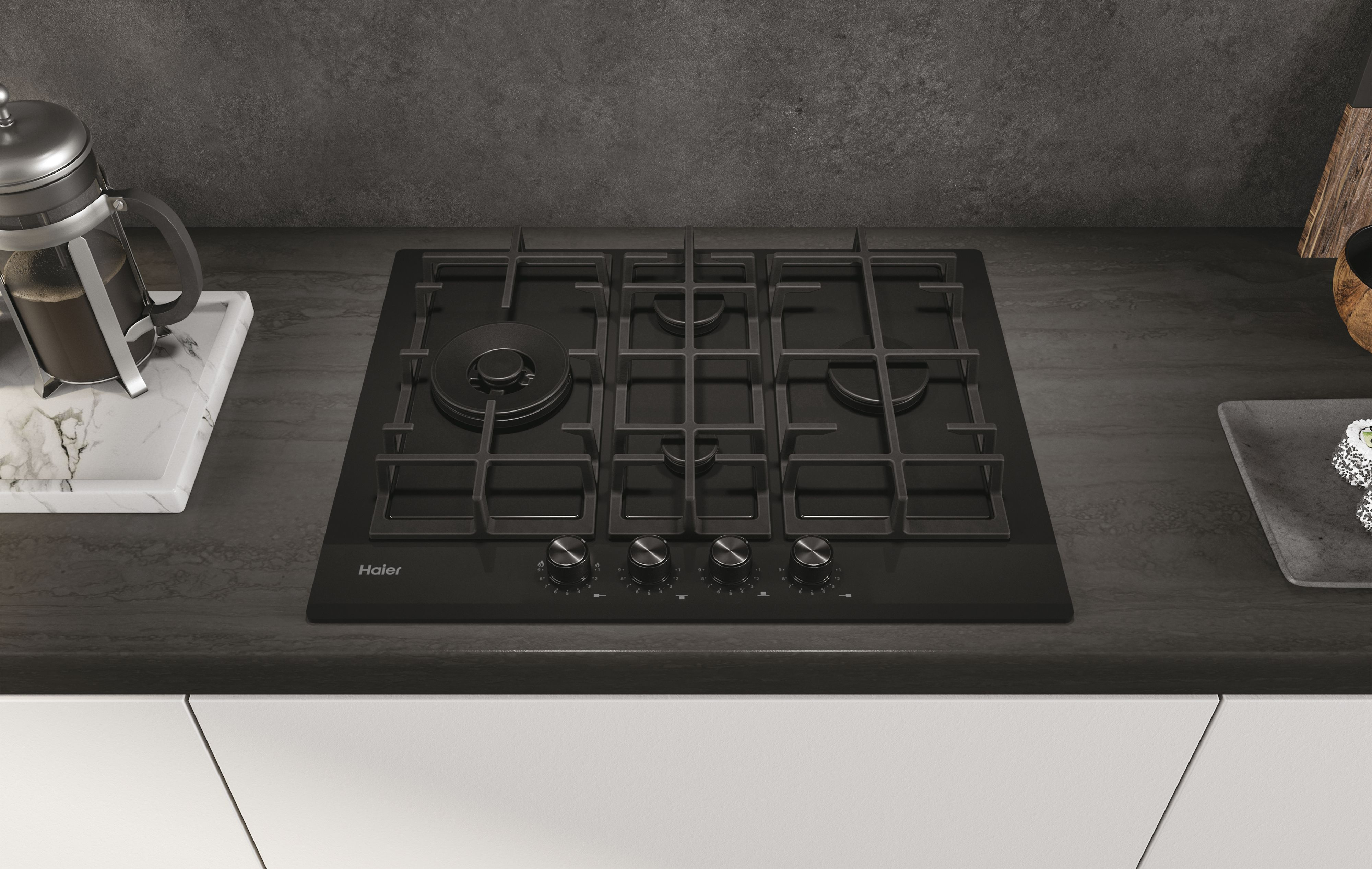 Piano cottura a gas Haier nero su un piano di lavoro con bruciatori e manopole. Cucina.