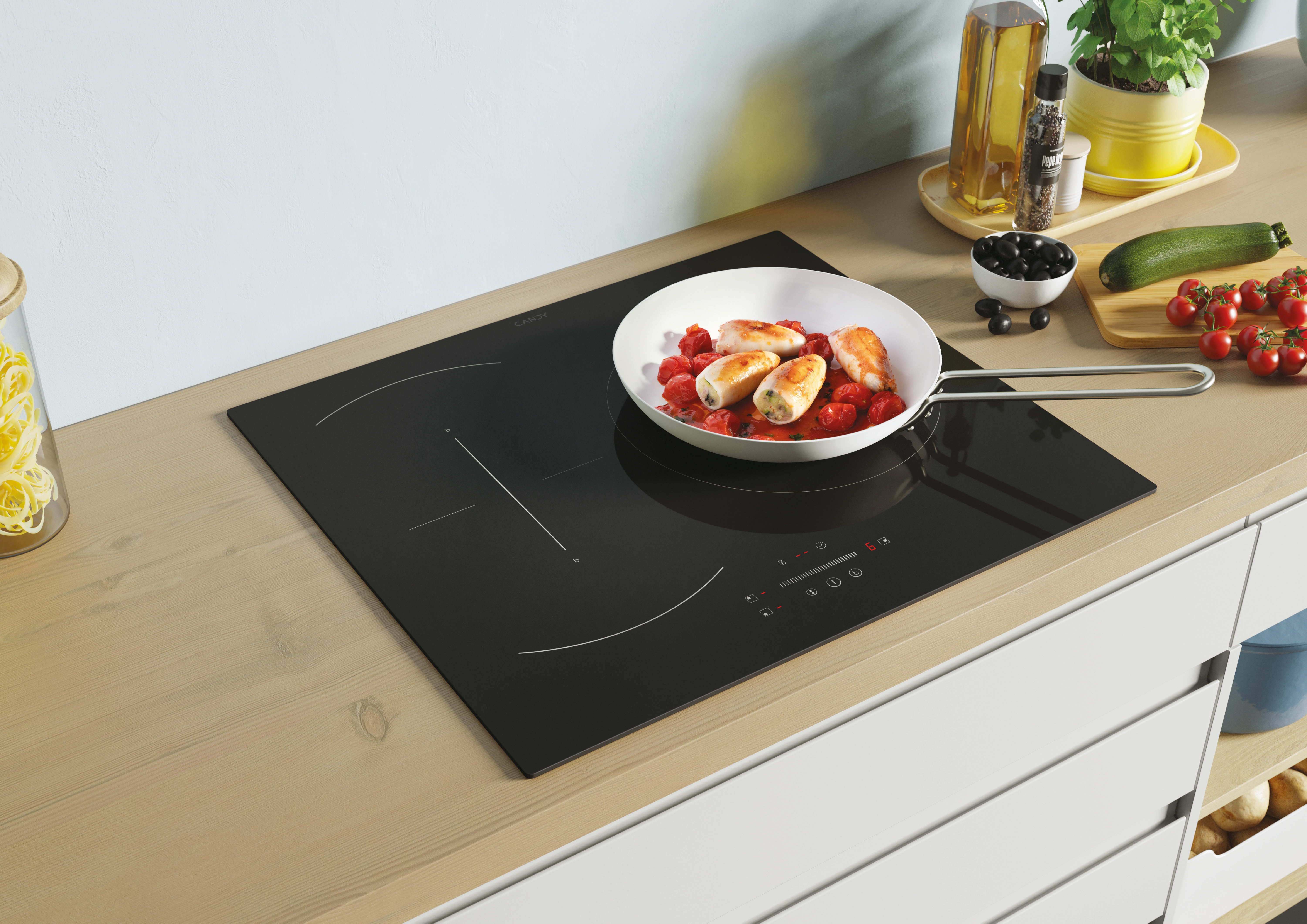 Placa de inducción con comida cocinándose en una sartén, con tomates y verduras.