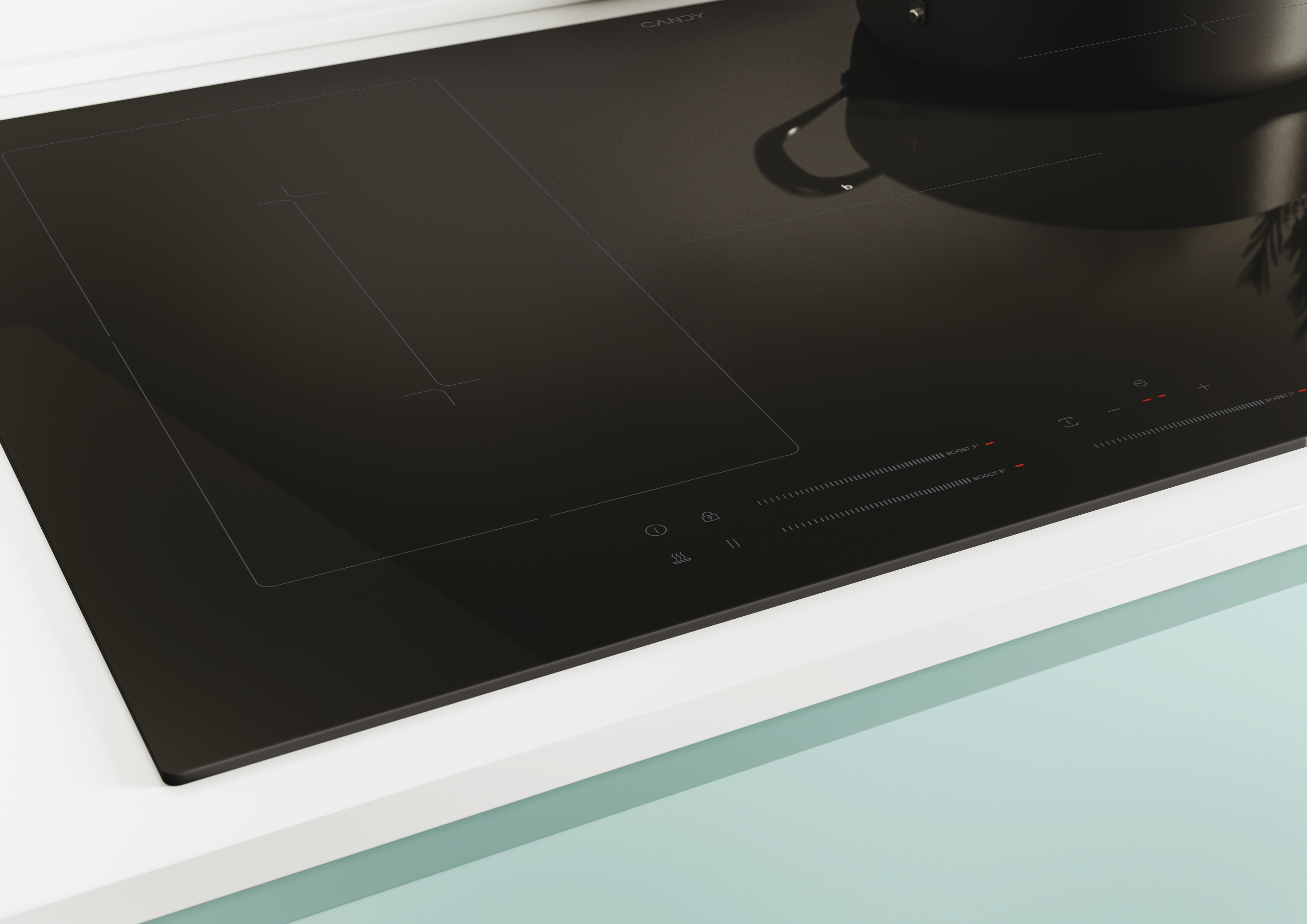 Widok z bliska czarnej płyty grzejnej z marką Candy, na białym blacie.