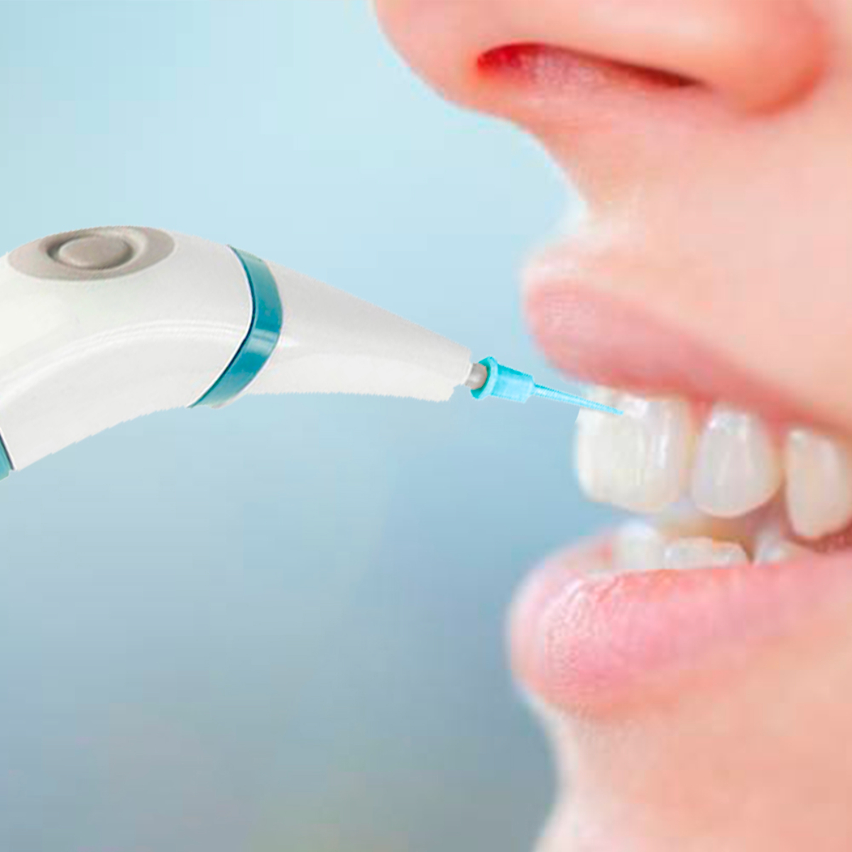 Primer plano de la boca de una persona que se limpia con un irrigador dental, mostrando los dientes y la punta del dispositivo.
