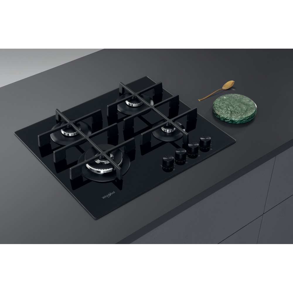 Una placa de cocina de gas negra con cuatro quemadores y perillas de control sobre una encimera gris oscuro.