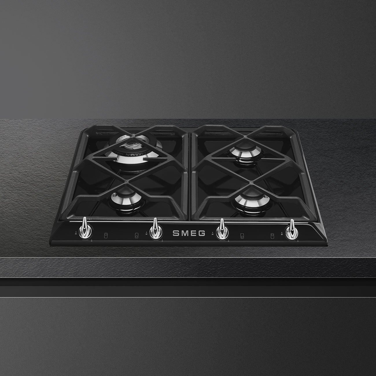 Una placa negra con cuatro quemadores, con un logotipo de SMEG y las perillas.