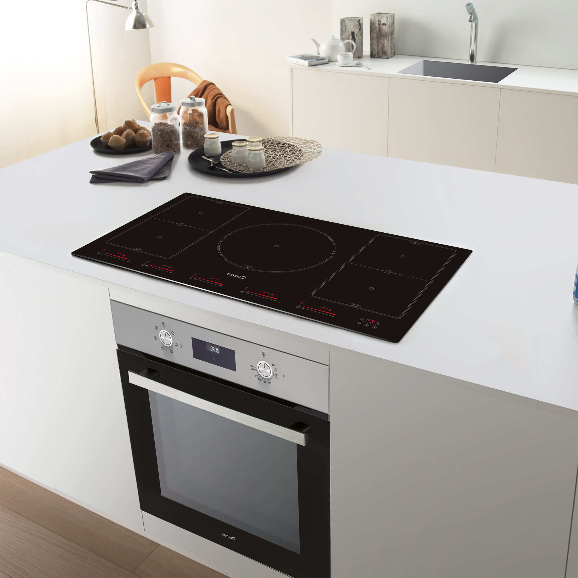 Una cocina moderna con encimera blanca. Una placa de inducción negra encima.