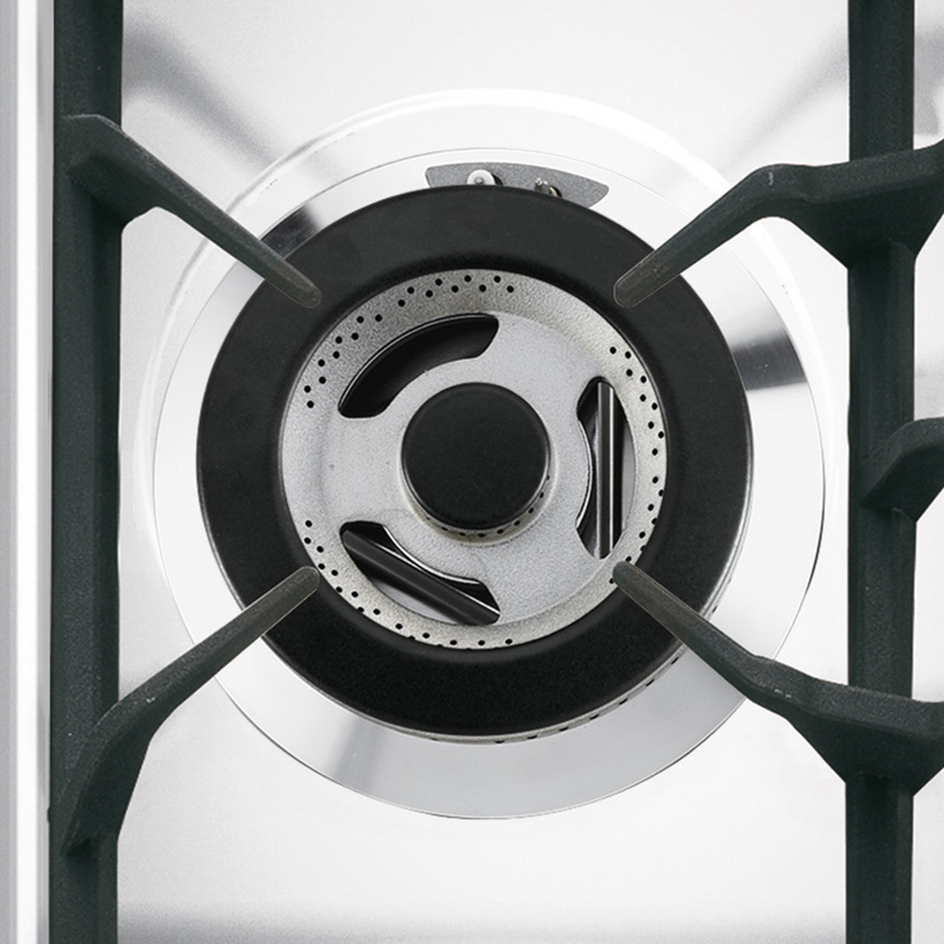Primer plano de un quemador de gas. Es plateado y negro, y tiene un diseño circular.