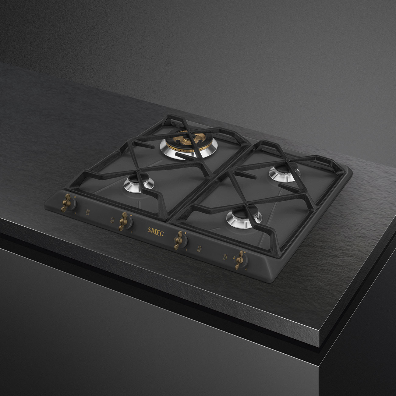 Czarna płyta grzewcza z czterema palnikami, ciemnoszarą powierzchnią i złotymi pokrętłami.