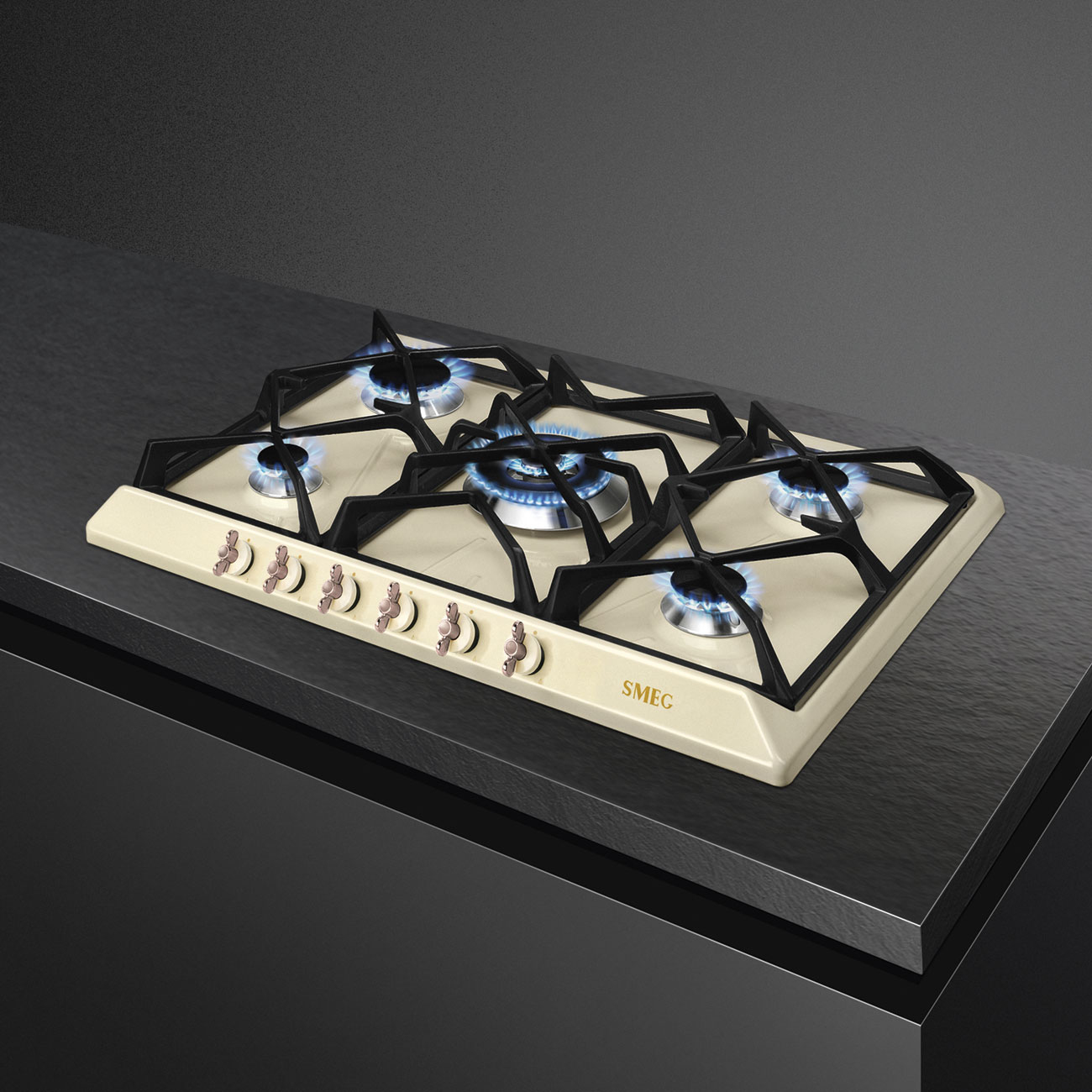 Kremowa płyta gazowa z niebieskimi płomieniami na czarnym blacie.