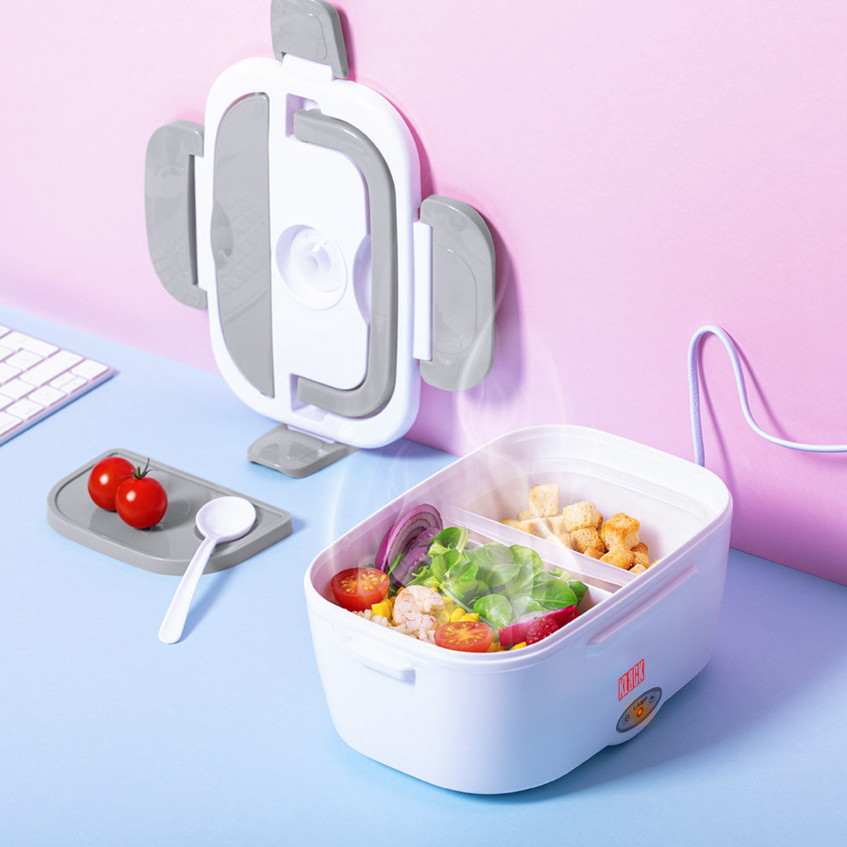 Fiambrera blanca con comida. El vapor se eleva del recipiente abierto, mostrando ensalada y pan.