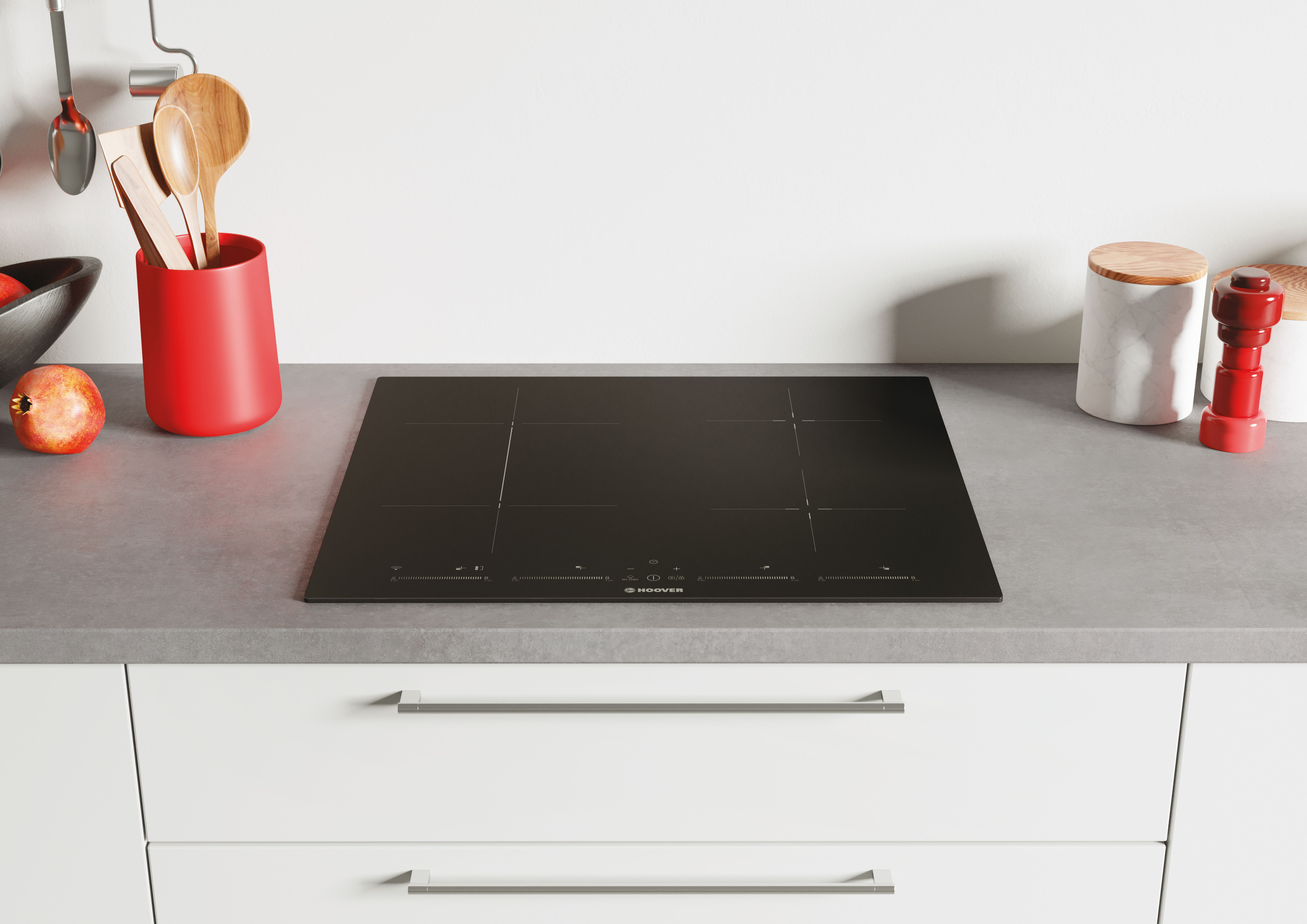 Czarna płyta Hoover na blacie, aranżacja kuchni z przyborami i dekoracjami.